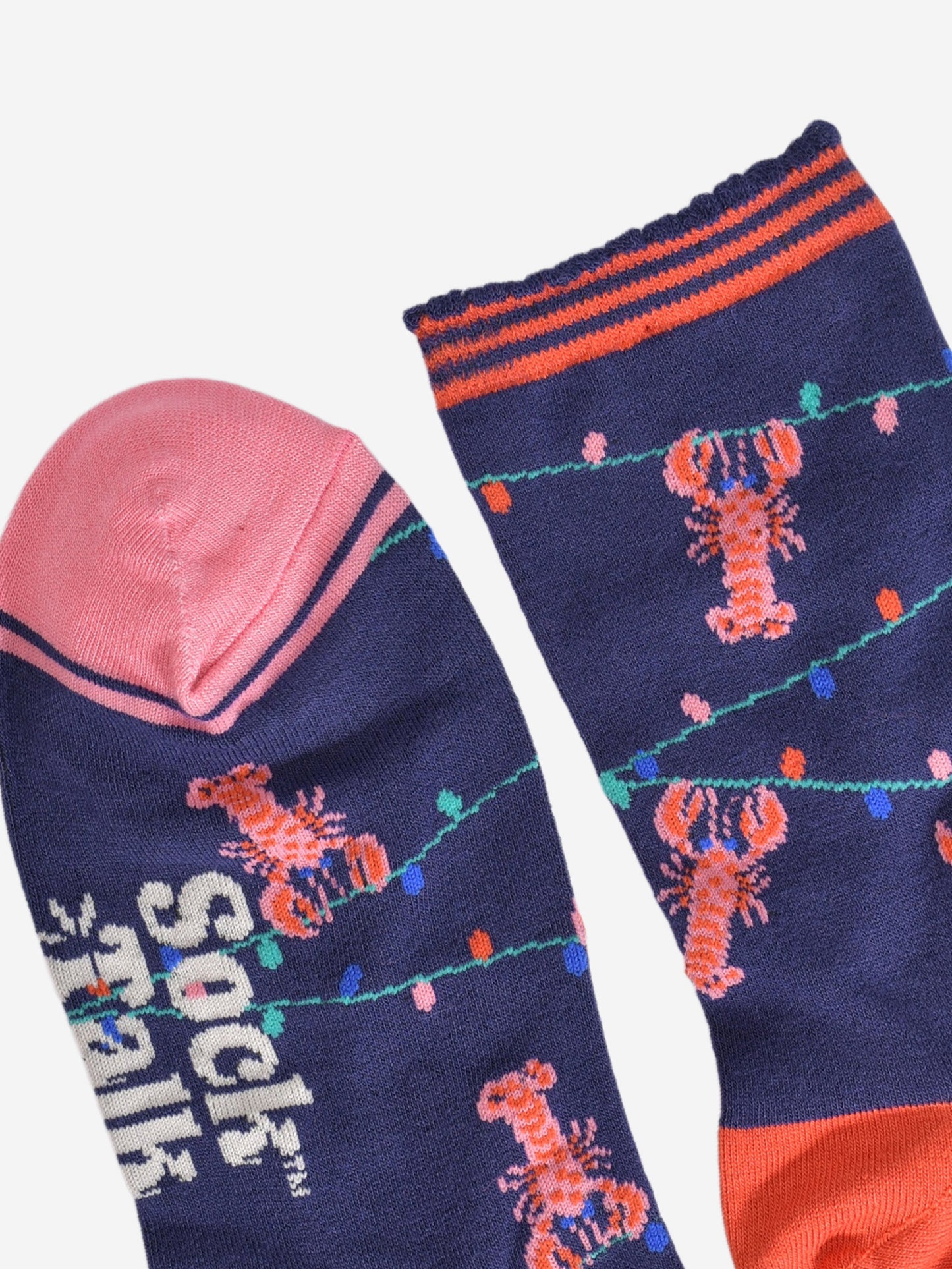 close up of the toe and cuff, the toe is pink with a navy blue border stripe, the cuff is scalloped and had coral orange stripes