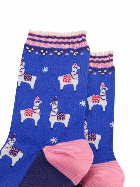 red bamboo socks with a navy striped cuff featuring a pattern of llamas wearing party hats and party lights