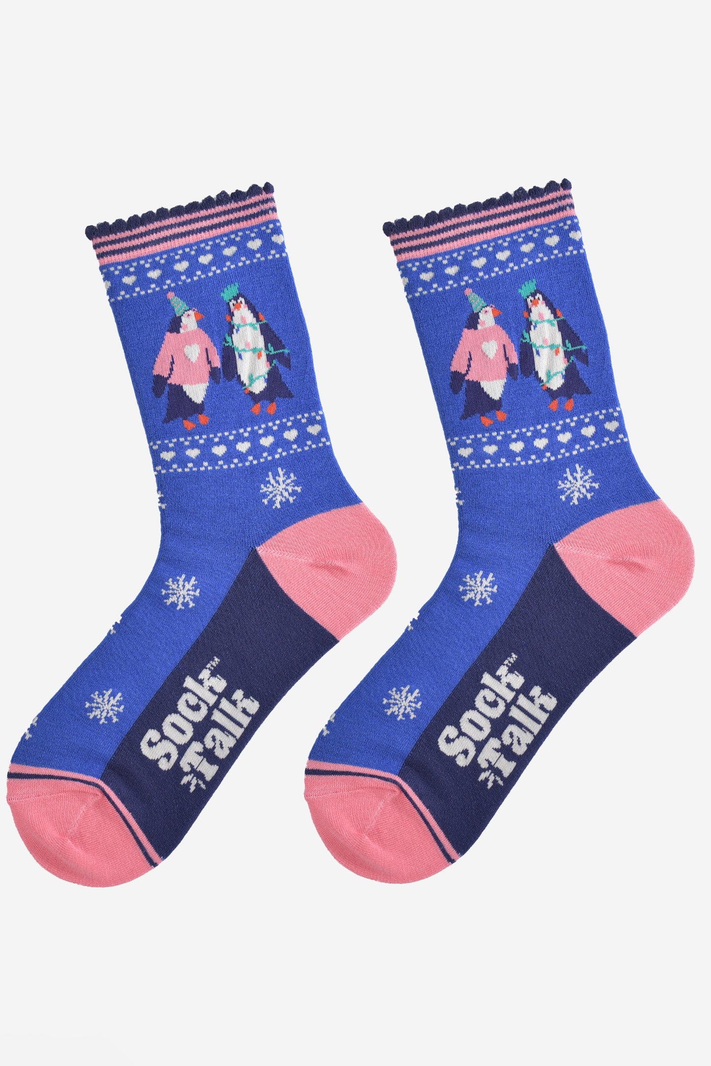 party penguin socks laying flat, showing a pattern of white snowflakes and love hearts, the socks have pink toe, heel and pink striped cuffs