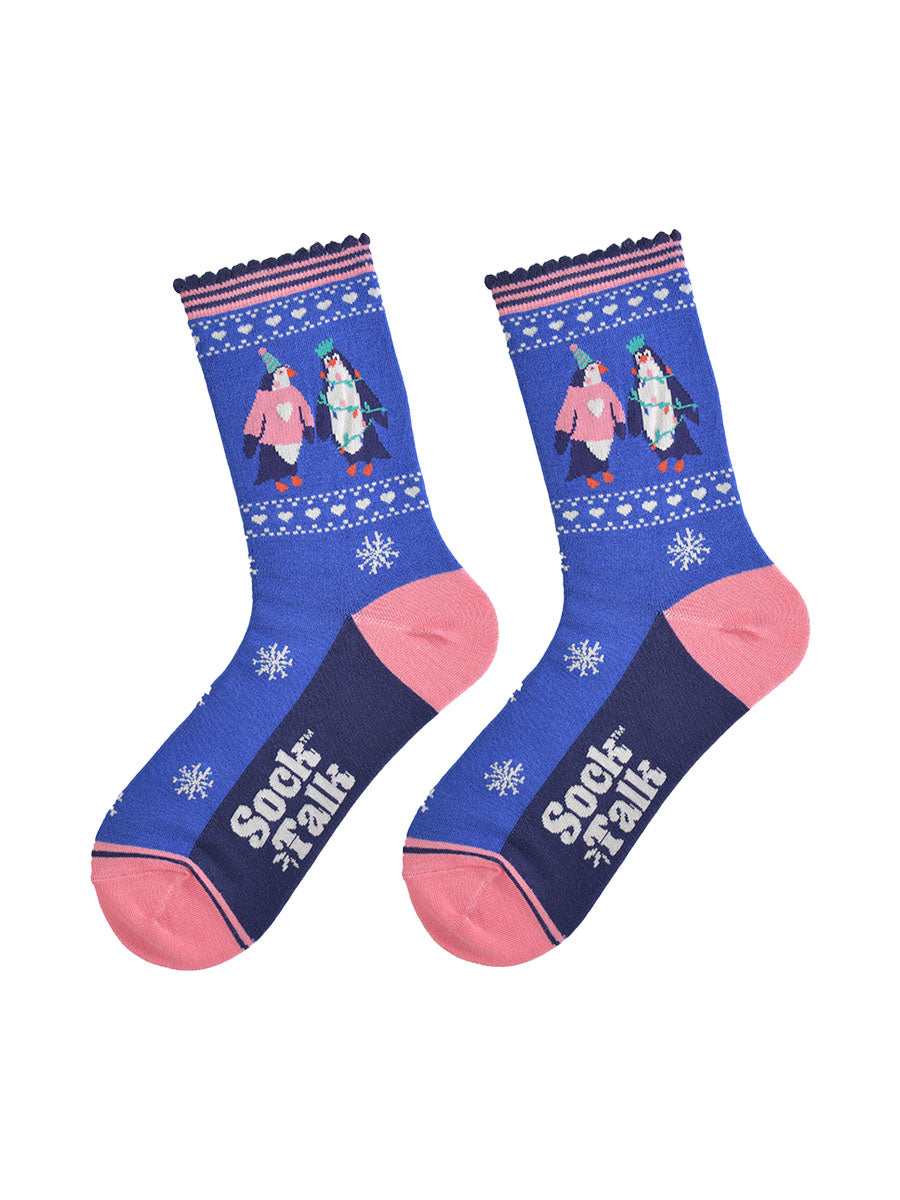 party penguin socks laying flat, showing a pattern of white snowflakes and love hearts, the socks have pink toe, heel and pink striped cuffs