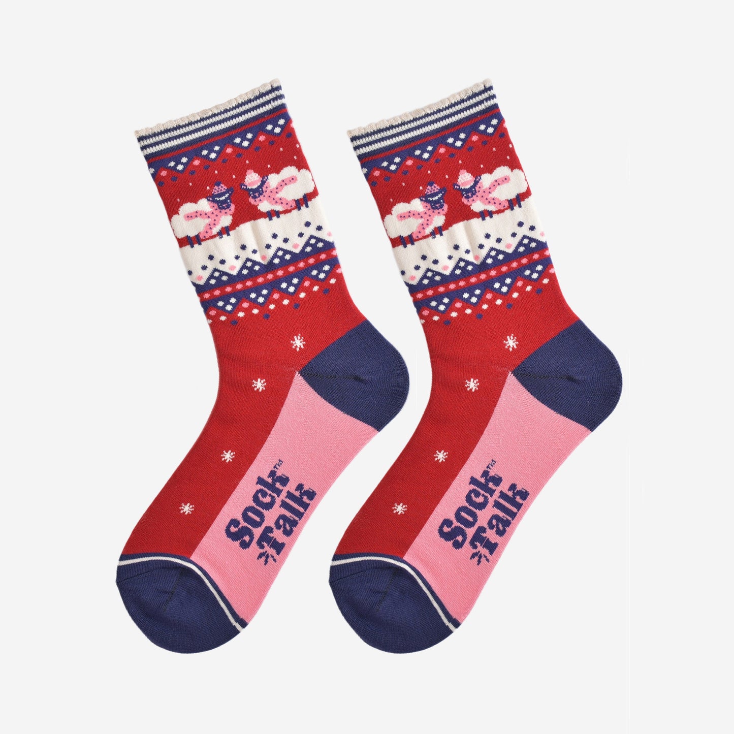 showing the socks laying flat, they have a pink sole and navy blue toe and heel in contrast to the red base of the socks. on the ankles there are sheep standing in a snowy field while wearing pink winter hats and scarves