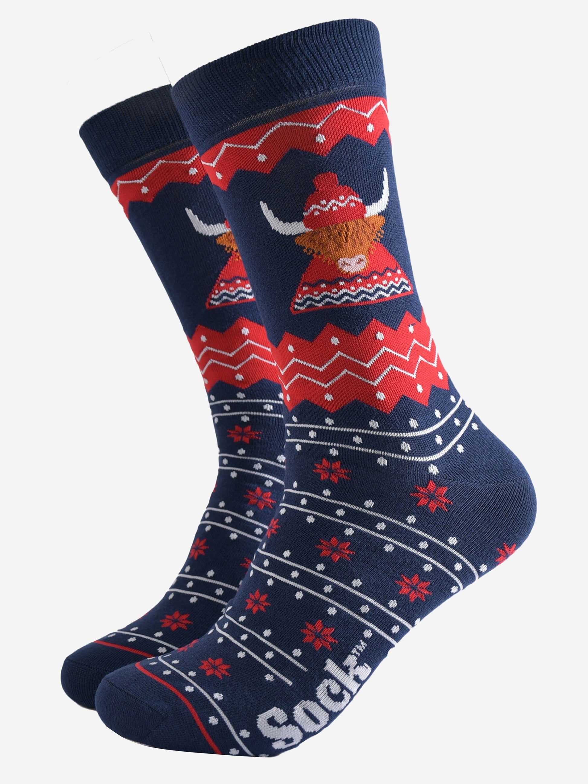 navy blue and red fair isle socks featuring a highland cow wearing a traditional knitted fair isle hat and jumper