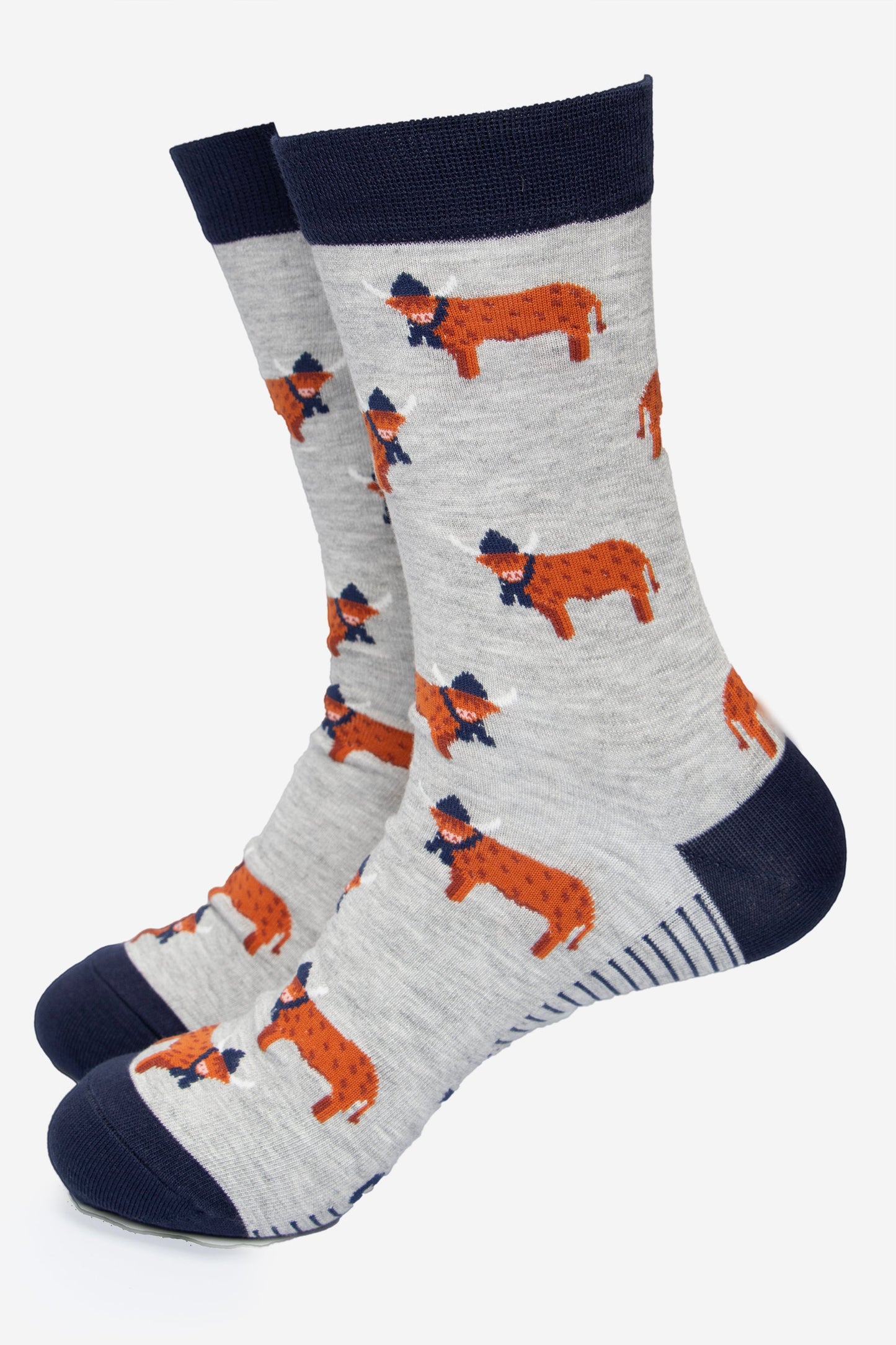 grey dress socks with a navy blue heel, toe and cuff with an all over pattern of orange standing highland cows, the cows are wearing winter hats and scarves