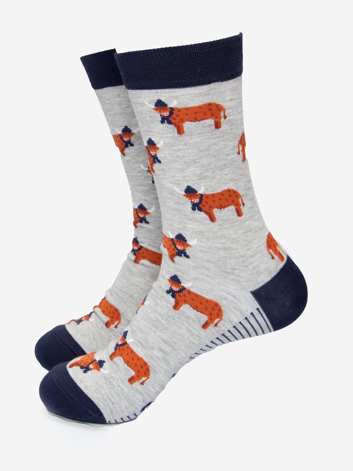 grey dress socks with a navy blue heel, toe and cuff with an all over pattern of orange standing highland cows, the cows are wearing winter hats and scarves