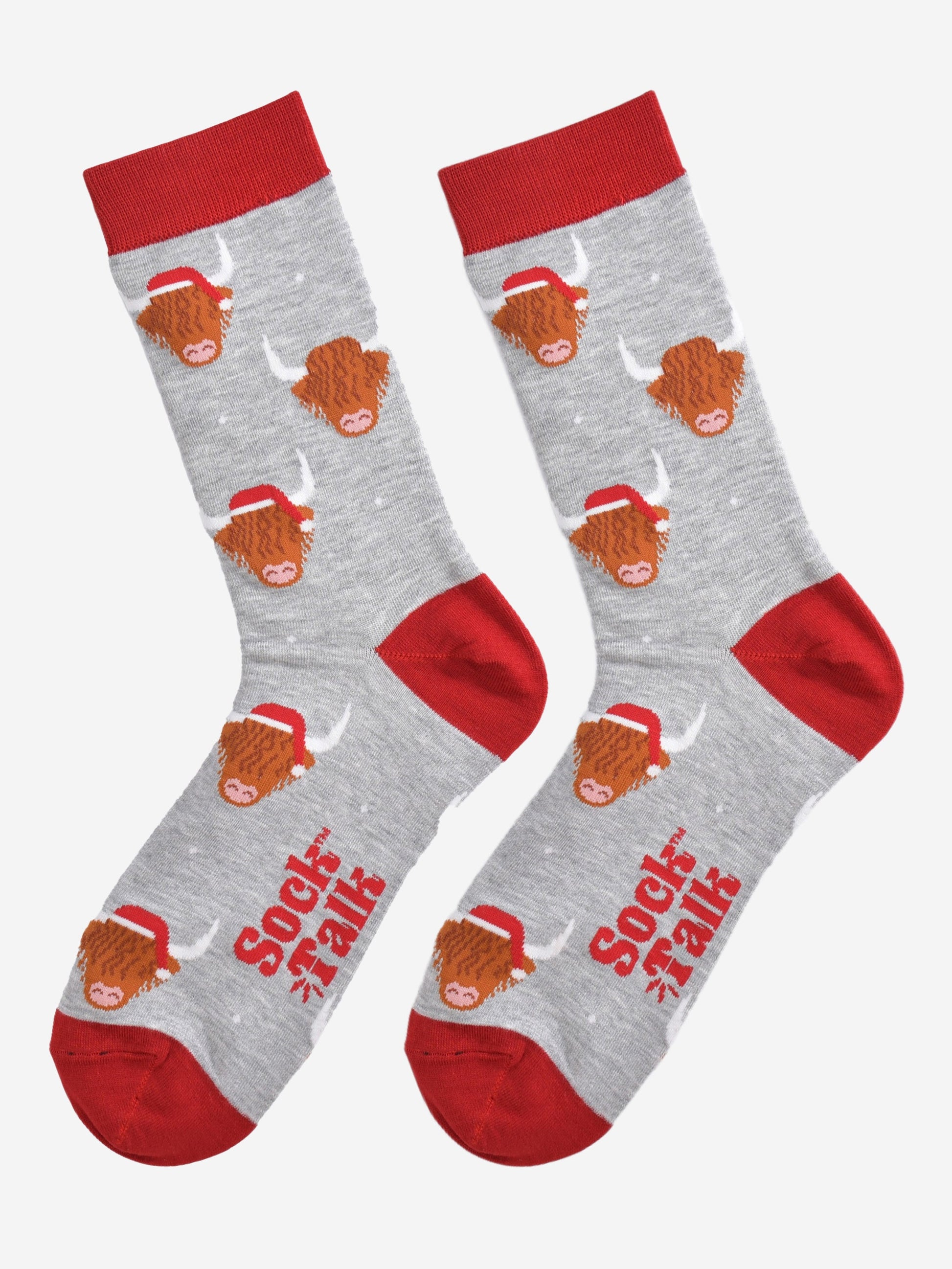 grey and red bamboo socks laying flat, showing the all over pattern featuring highland cows wearing red santa hats
