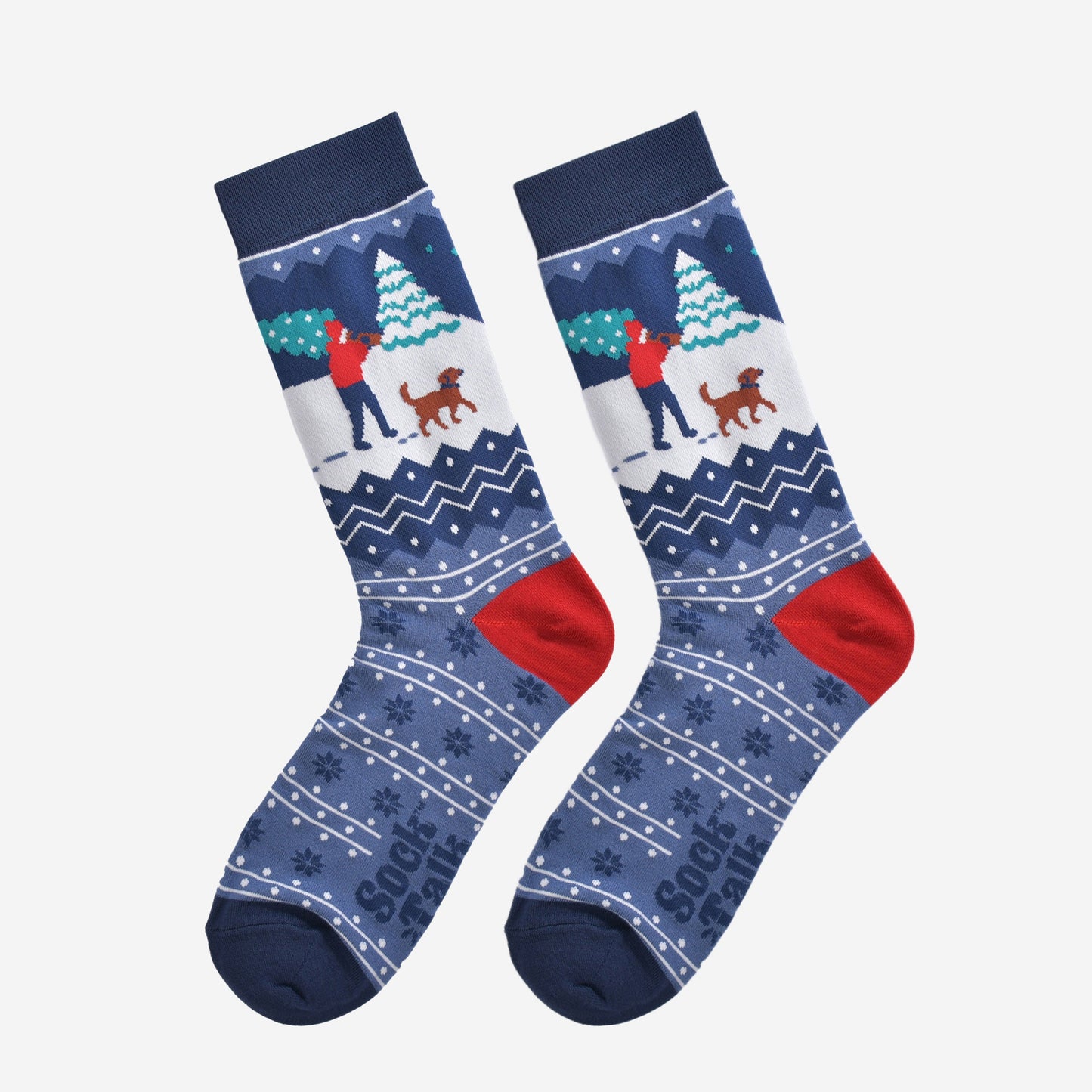 christmas man and dog socks laying flat, showng the blue fair isle pattern and festive winter dog walker scene