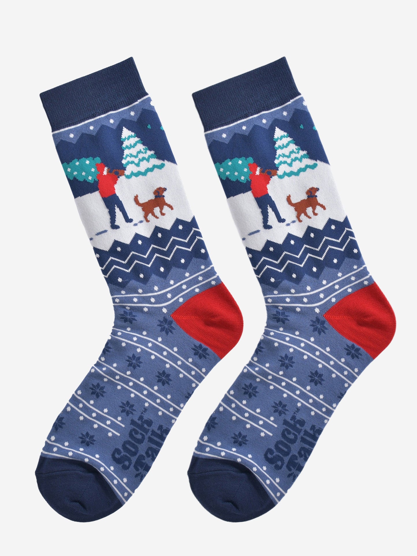 christmas man and dog socks laying flat, showng the blue fair isle pattern and festive winter dog walker scene