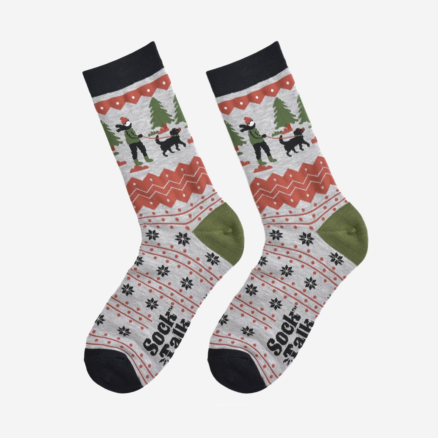 showing the socks laying flat, the toe is black, the heel is green and the fair isle pattern is all over the design. the dog walker scene is prominent on the ankle