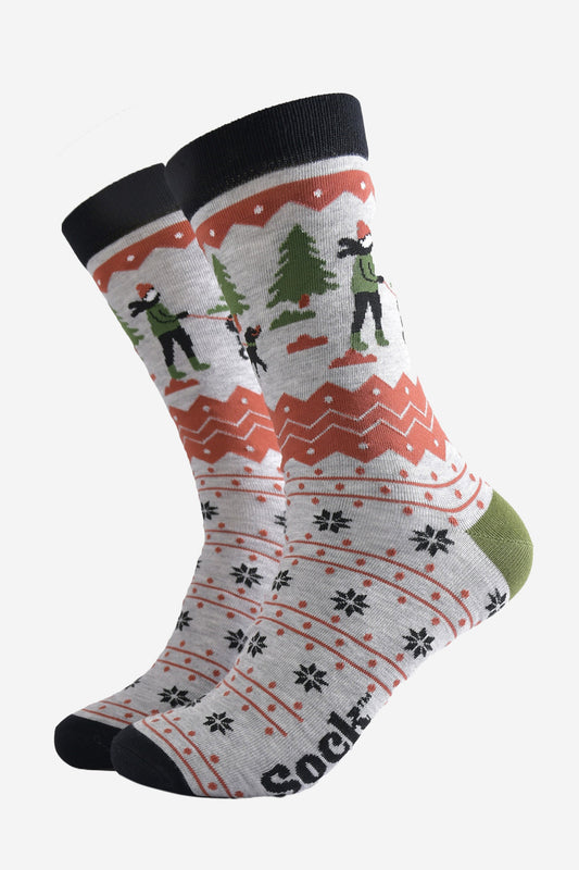 grey bamboo socks with a fair isle pattern in orange and black featuring a dog walker and a winter scene