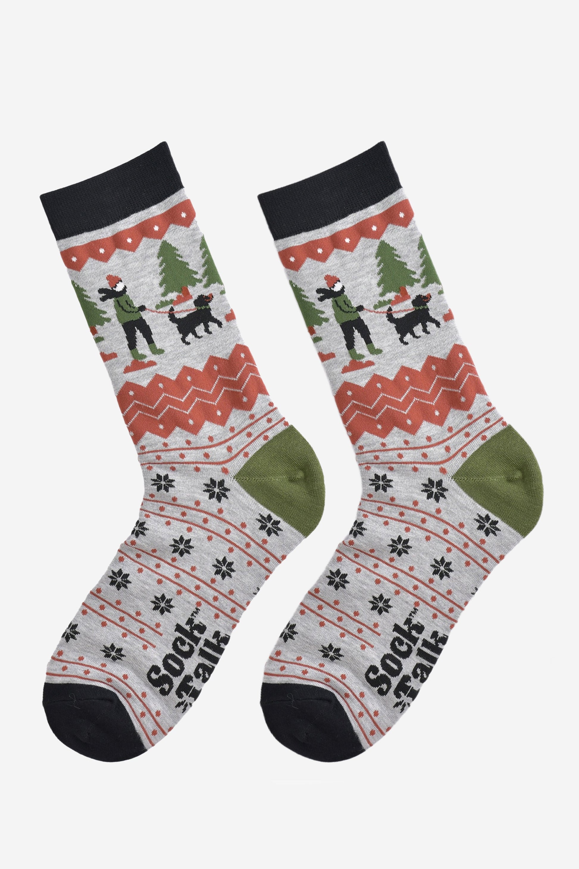 showing the socks laying flat, the toe is black, the heel is green and the fair isle pattern is all over the design. the dog walker scene is prominent on the ankle