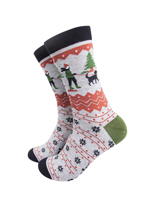 grey bamboo socks with a fair isle pattern in orange and black featuring a dog walker and a winter scene