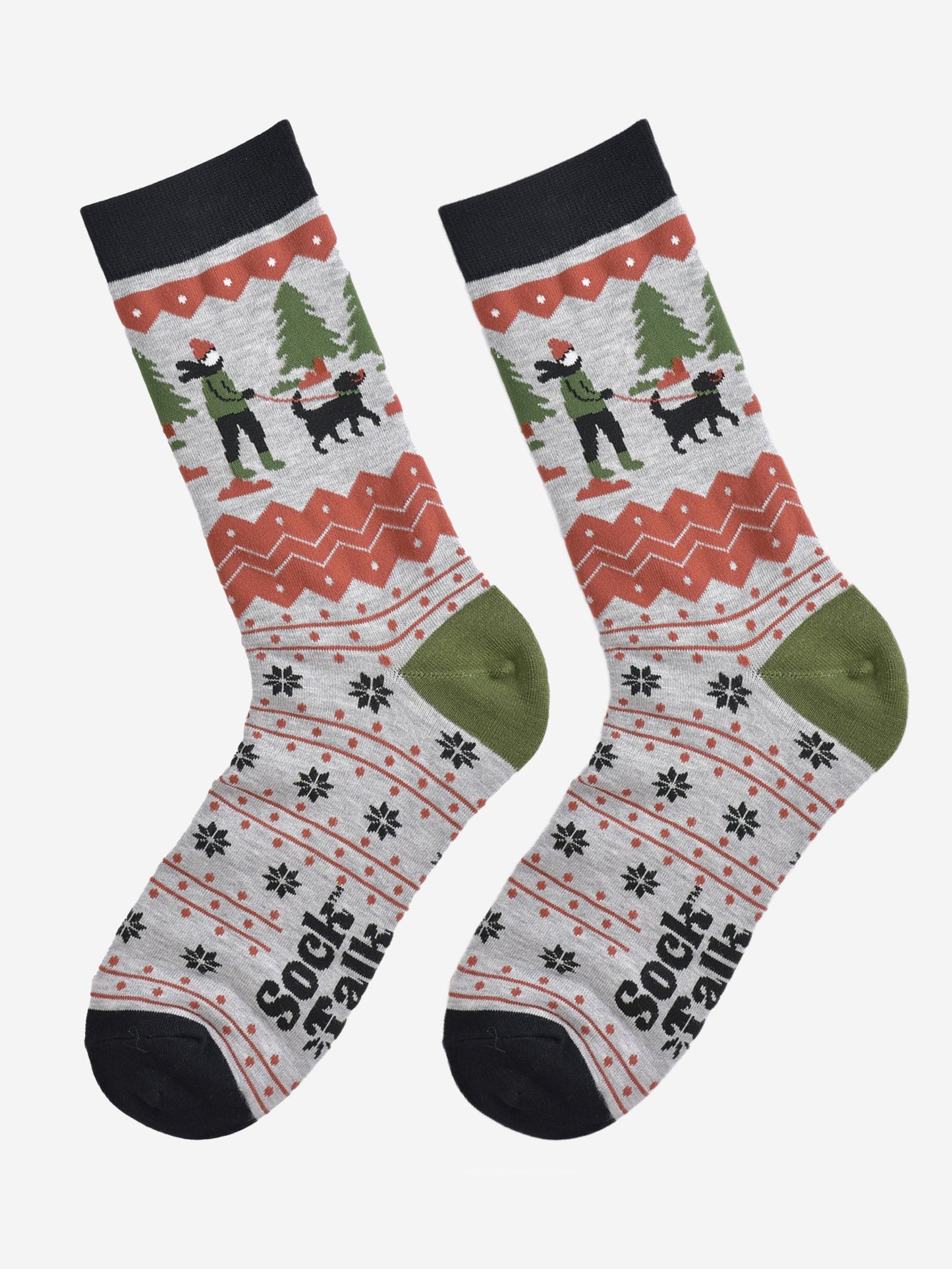 showing the socks laying flat, the toe is black, the heel is green and the fair isle pattern is all over the design. the dog walker scene is prominent on the ankle