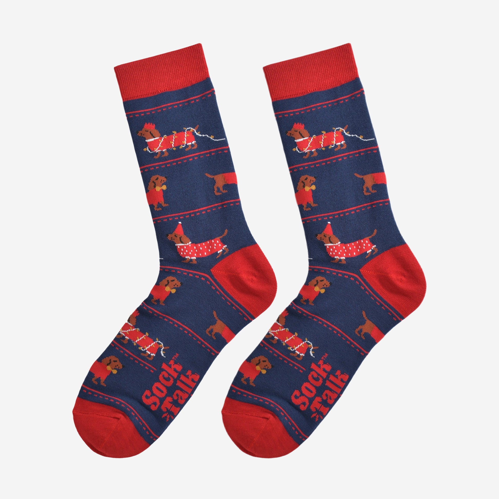 party sausage dog socks laying flat, showing the all over design with the dachshunds wearing red festive coats, party hats and being entangled in the party lights