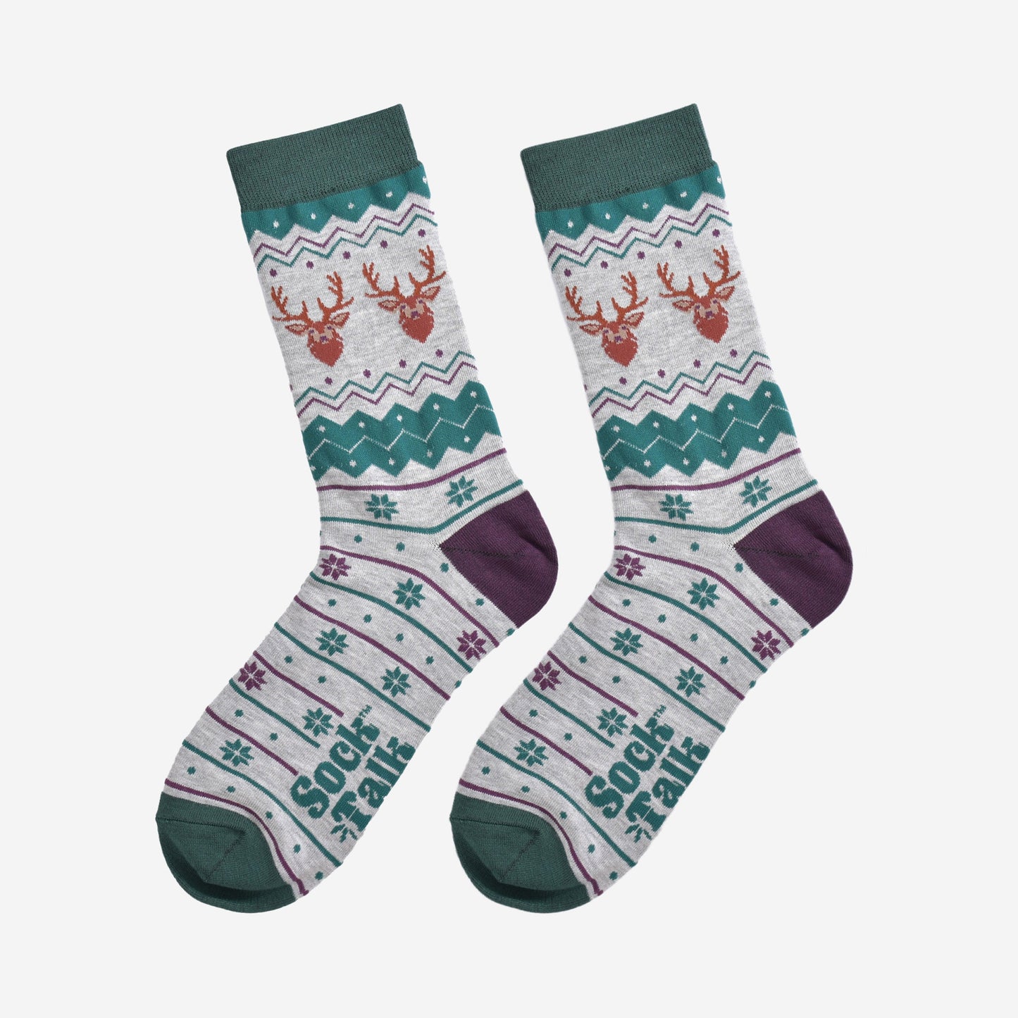 fair isle stag socks laying flat, showing the grey and green fair isle pattern and the two stags heads on each side of the ankles