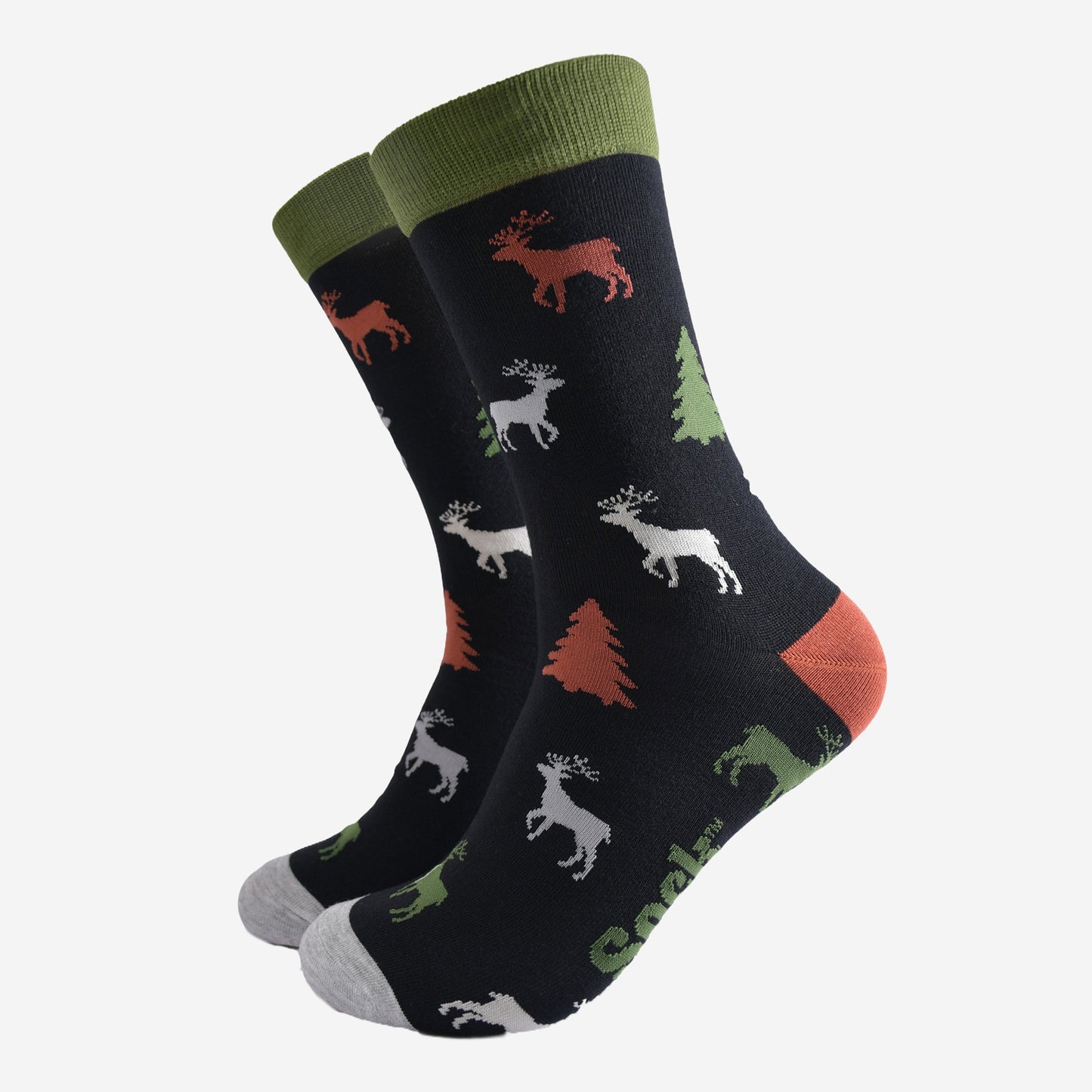 black crew socks with green cuff, grey toe and orange heel with a pattern of stags and christmas trees all over