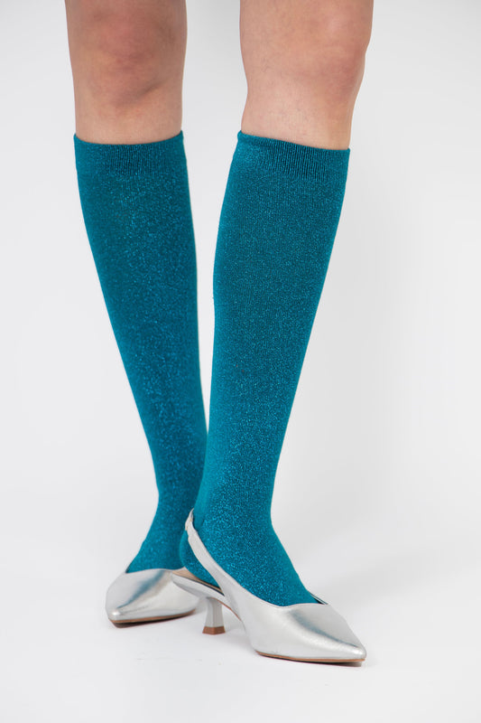 model wearing knee high sparkly teal glitter socks, showing the length of them when worn