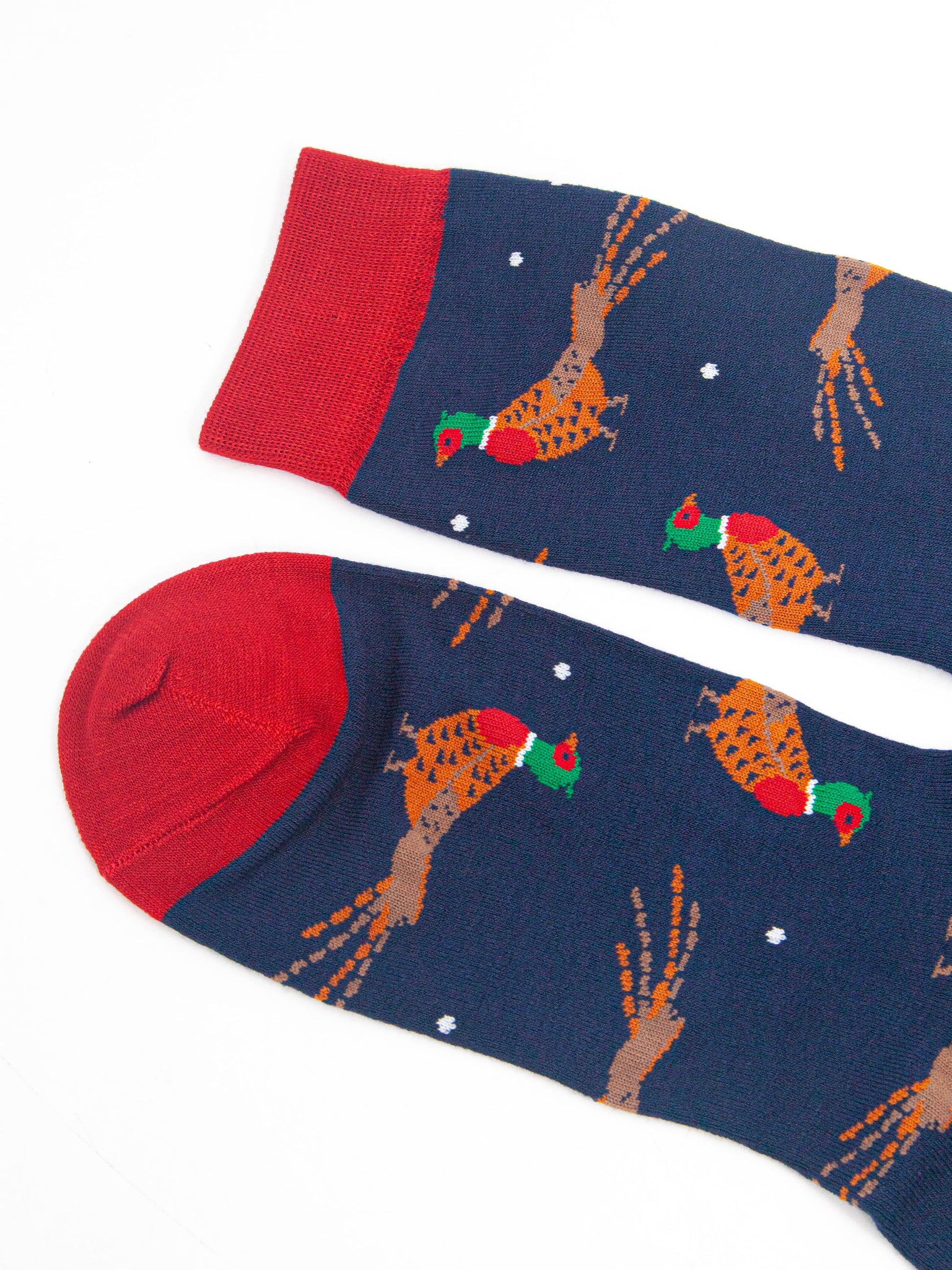 close up of the toe and cuff, both are red and contrast the navy blue base of the socks and complement the red accents on the pheasants