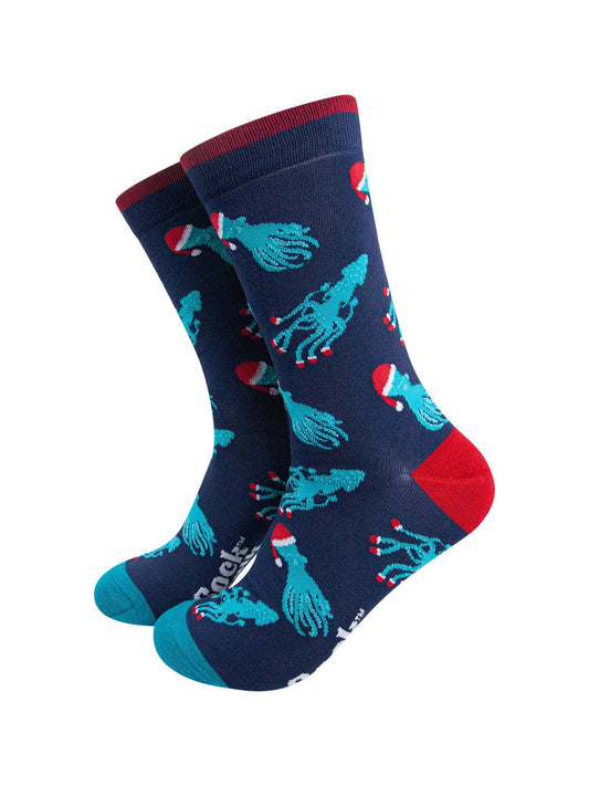 navy blue socks with an all over pattern of electric blue squid and octopus wearing santa hats
