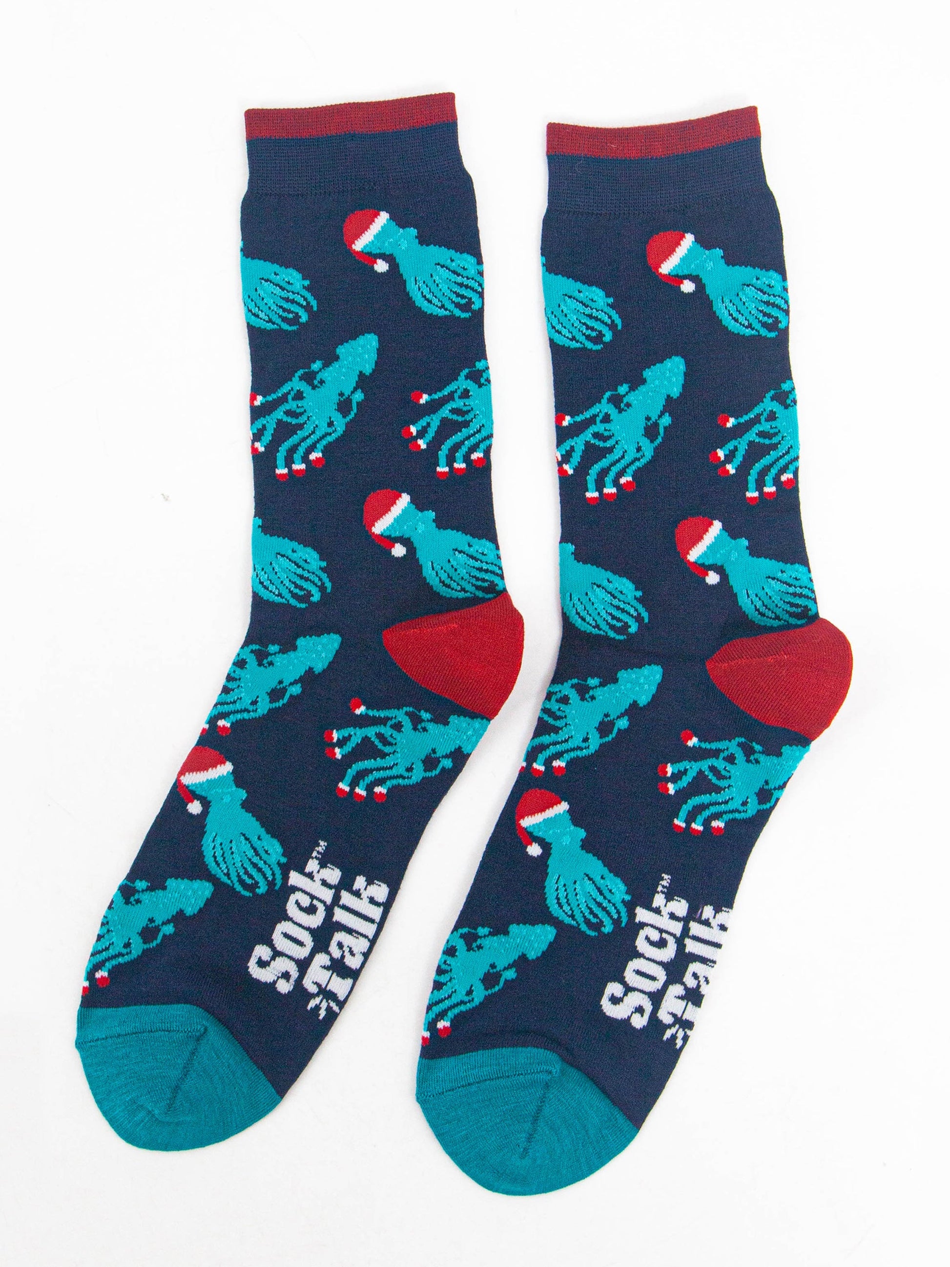 showing the christmas octopus and squid socks laying flat, there is an all over pattern of electric blue coloured squid and octopus wearing santa hats and santa slippers