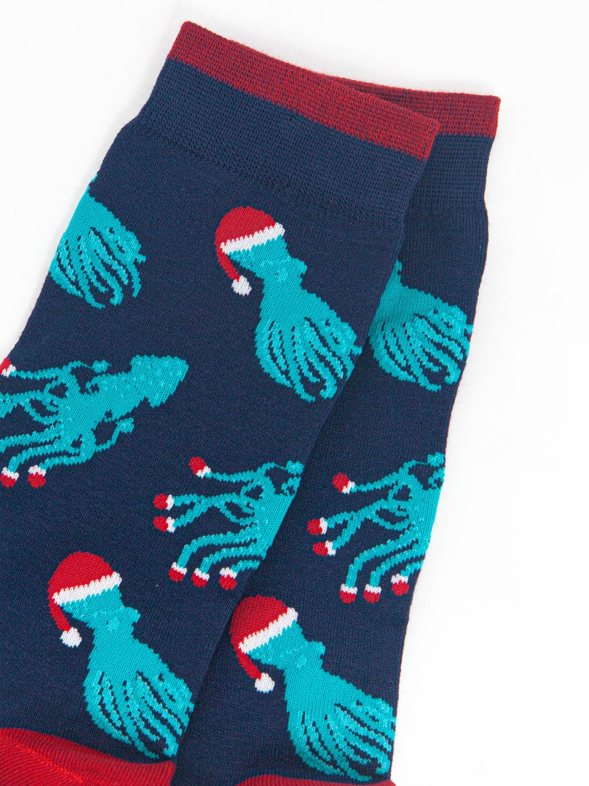 close up of the squid and octopus pattern, the octopus are wearing santa hats, the squid are wearing santa slippers on the ends of their tentacles