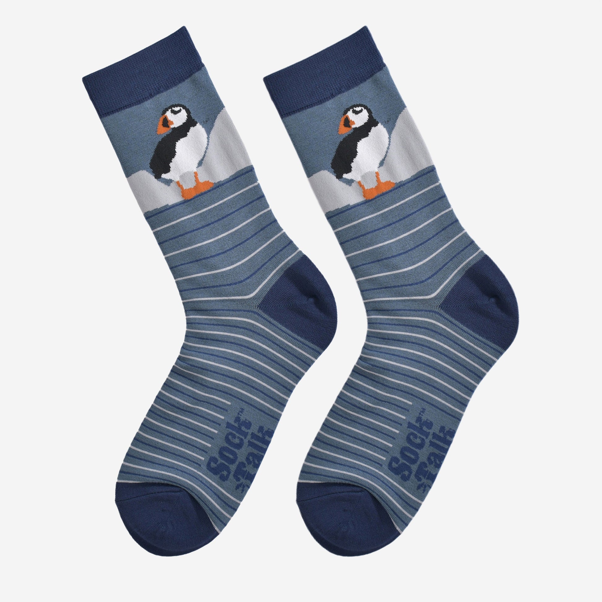 showing the striped puffin socks laying flat, showing the grey and blue stripes and the puffin design on the ankle.
