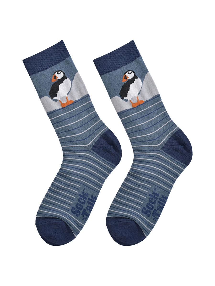 showing the striped puffin socks laying flat, showing the grey and blue stripes and the puffin design on the ankle.