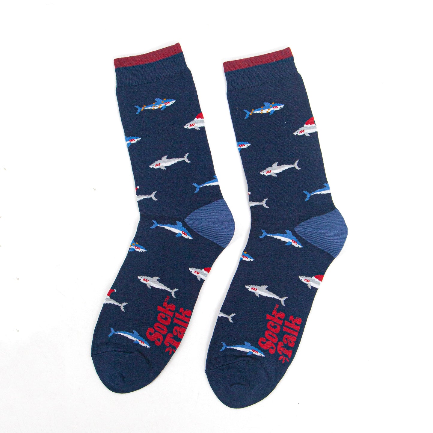 showing the shark socks laying flat, there is an all over pattern of swimming blue and grey sharks wearing festive hats and party lights