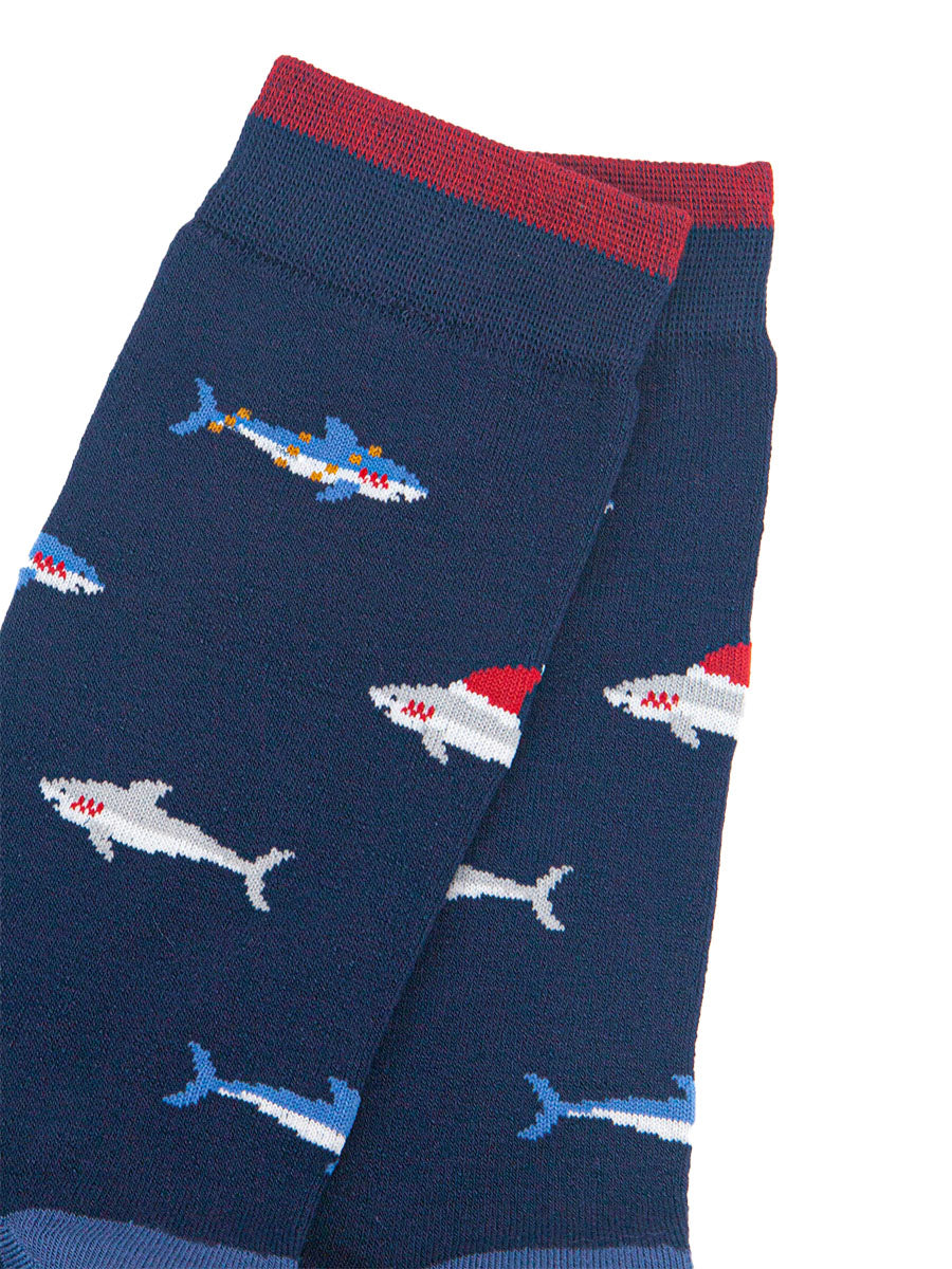 close up of the shark pattern, there are grey sharks wearing santa hats and blue sharks entangled in party lights
