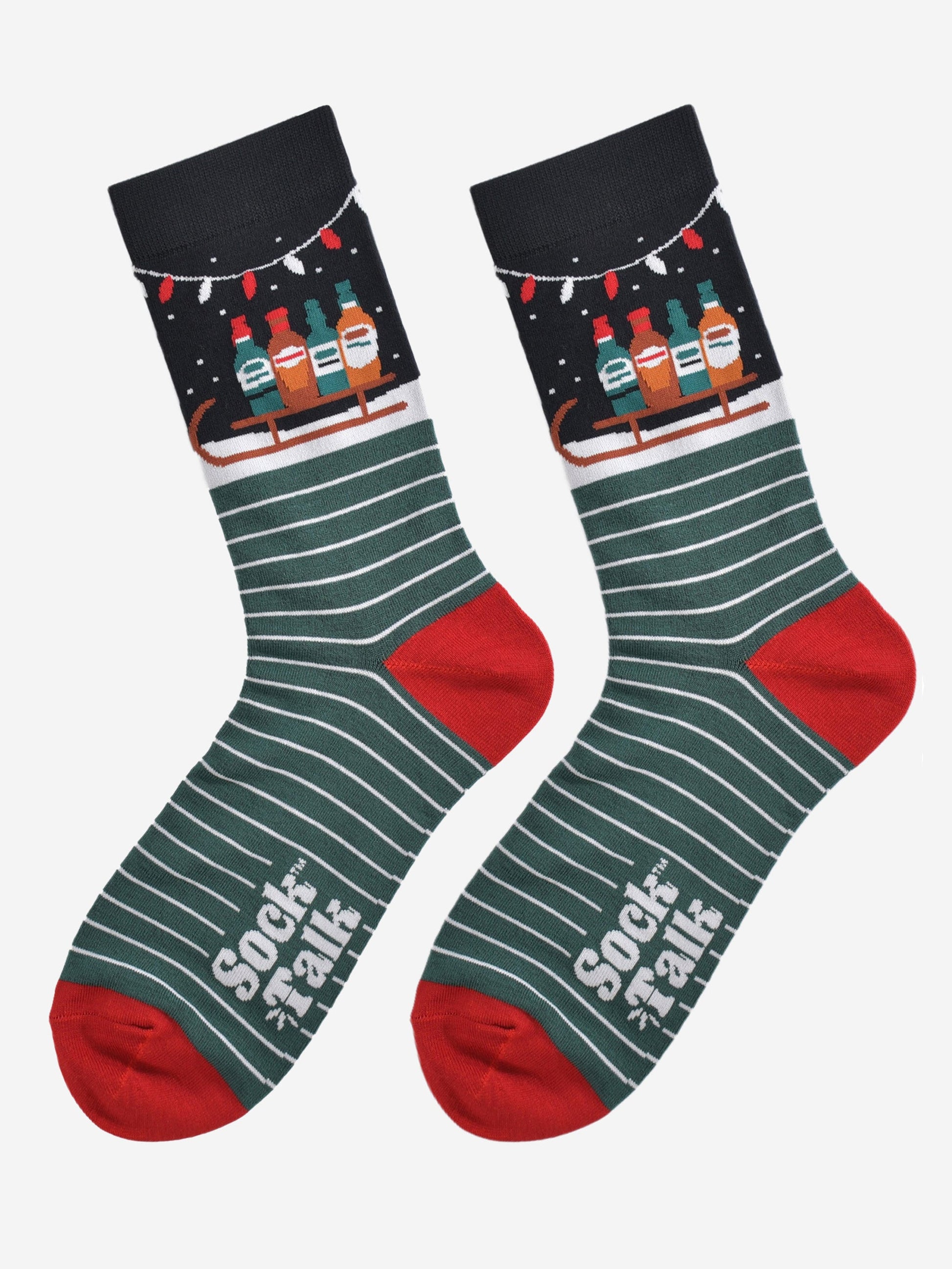 laying flat these socks show the green and white stripe pattern in contrast to the ankle which shows snow and a sledge carrying bottled party drinks