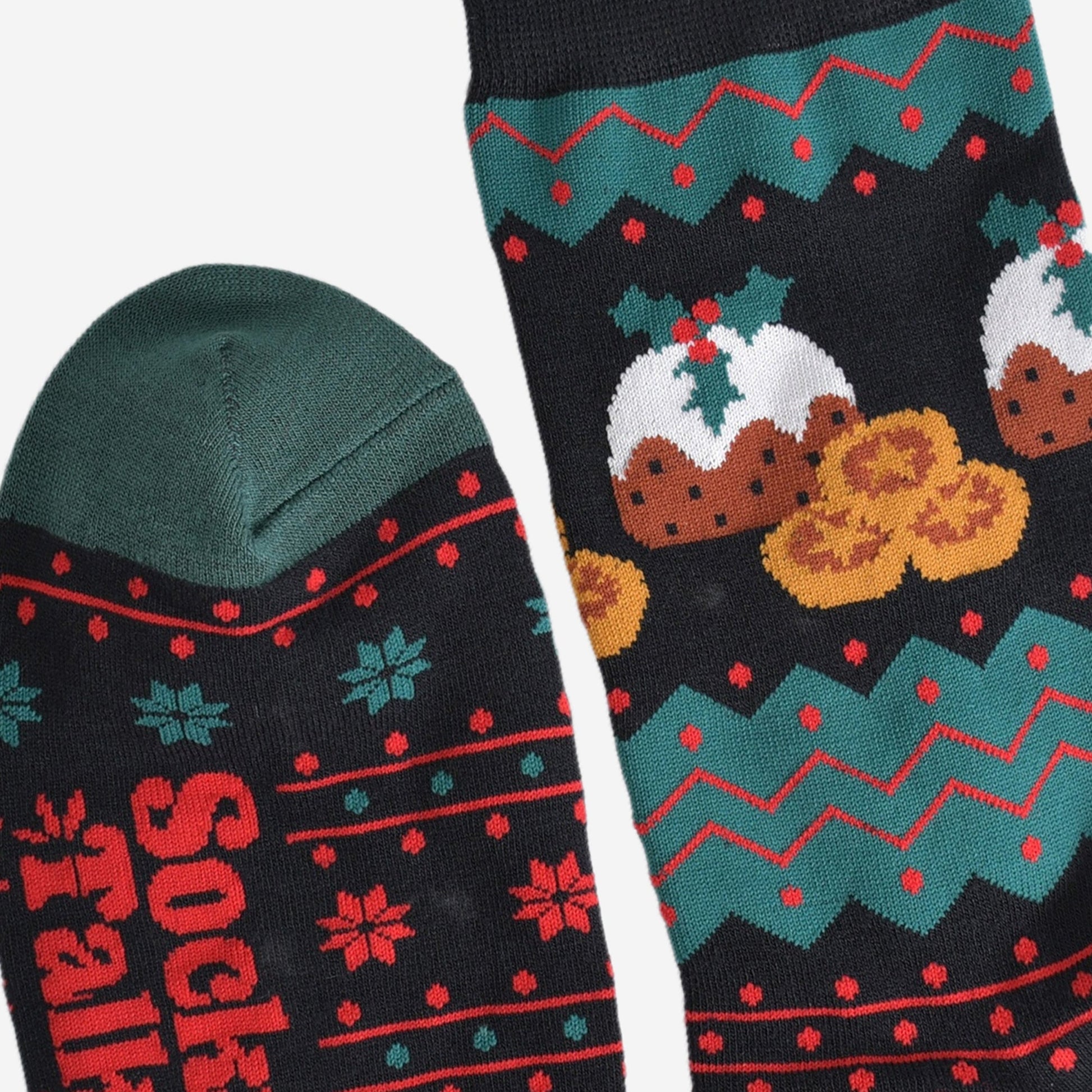 close up of the cuff and toe of the socks, the cuff is black and the toe is green, the fair isle pattern is shown clearly