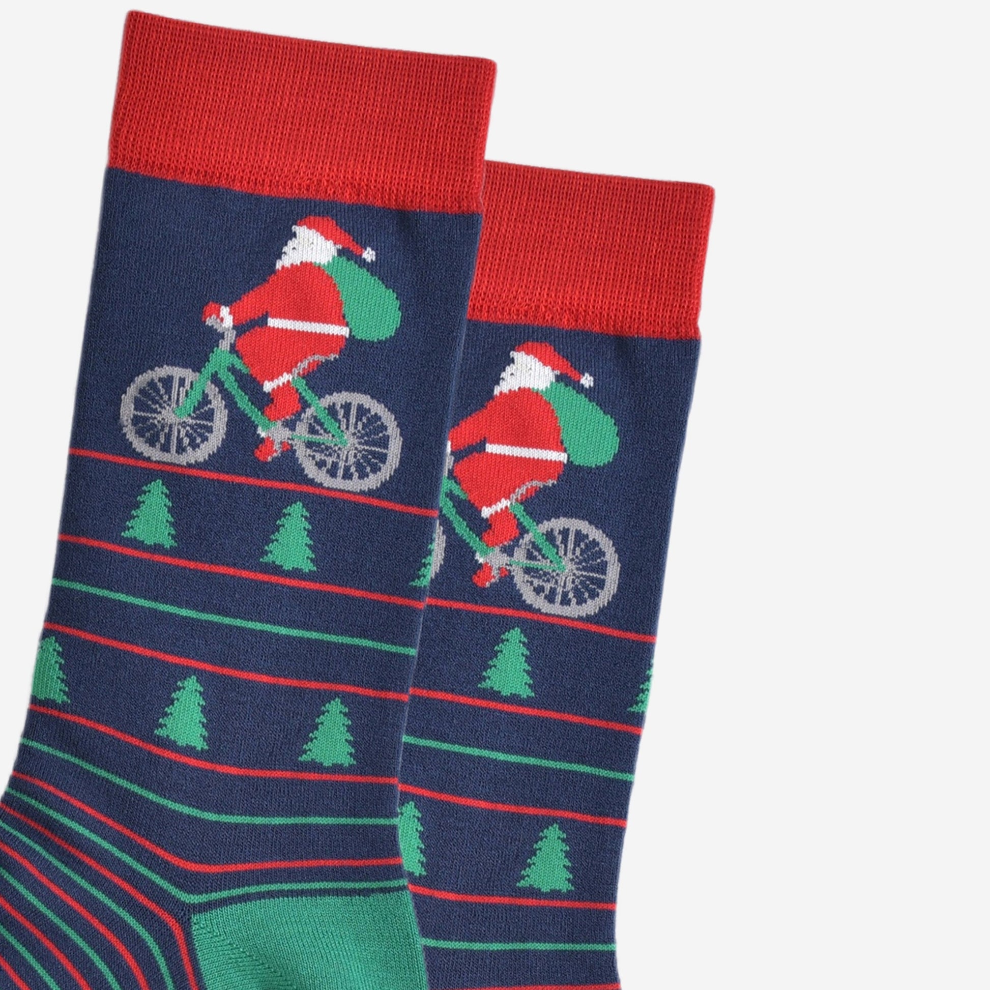 close up of santa claus on the bicycle, his bike is green and he is carrying a green sack of presents