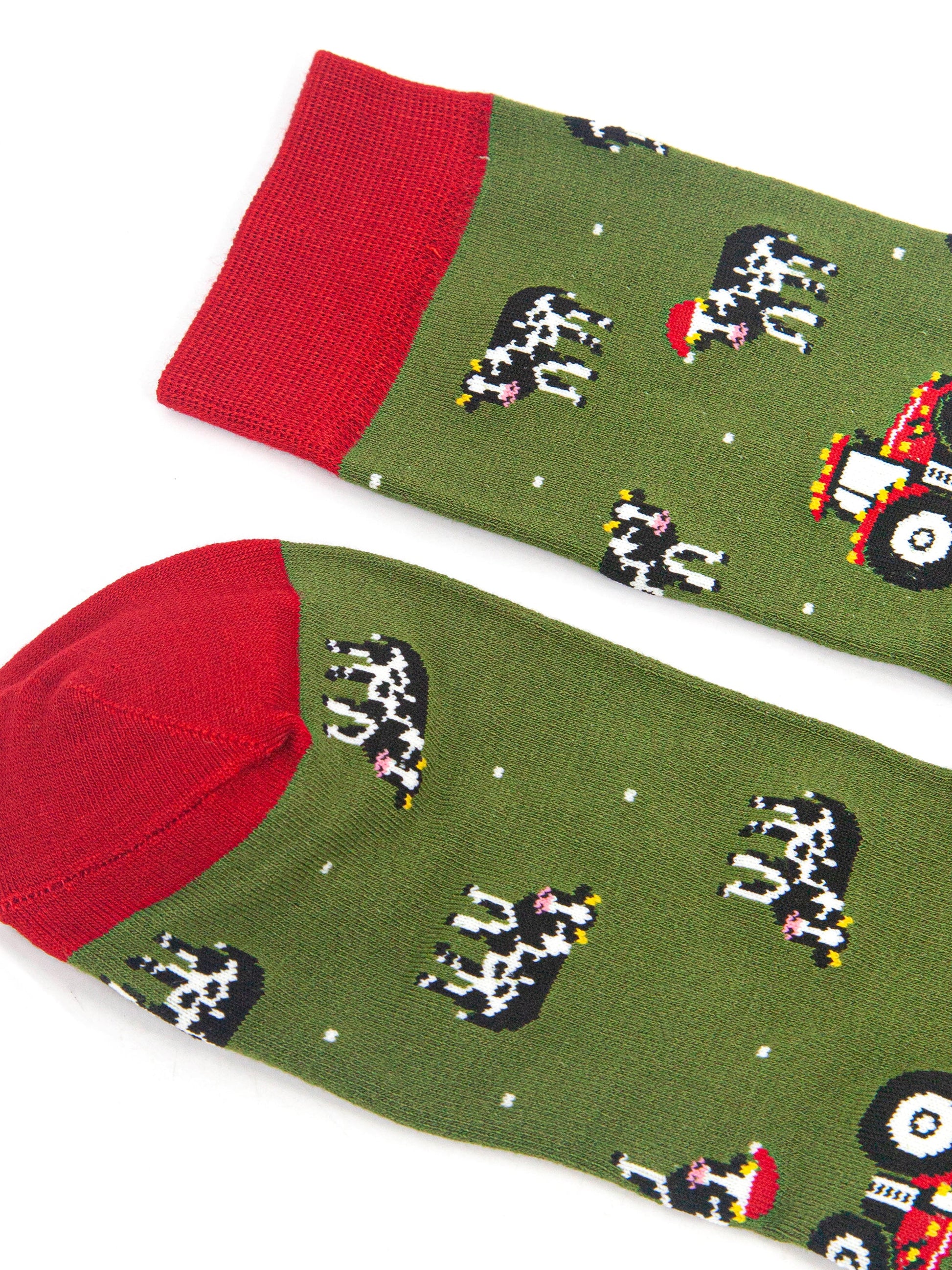 close up of the red heel and cuff on the socks, they contrast the green background of the design