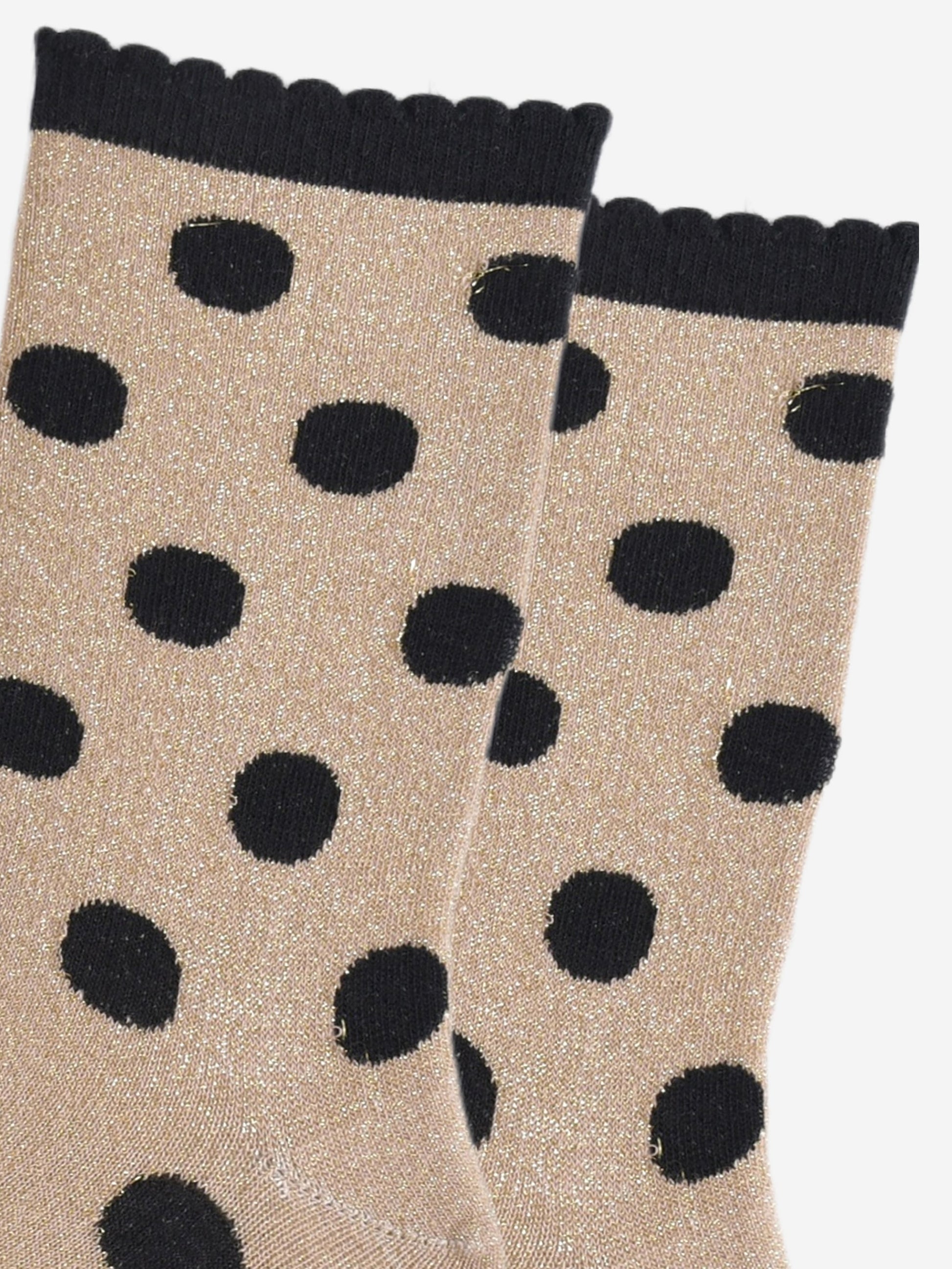 close up of the black polka dot pattern and all over silver glitter on the gold ankle socks