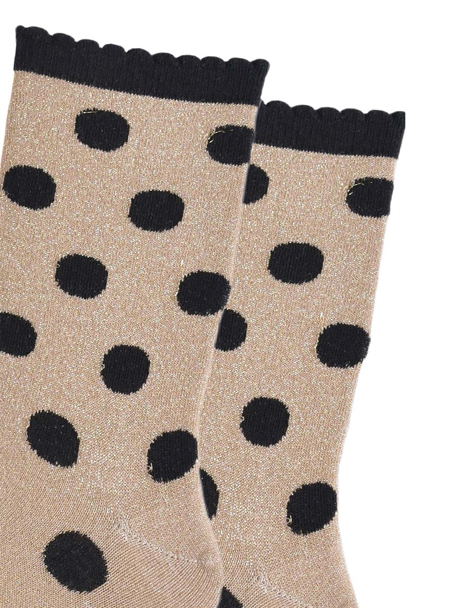 close up of the black polka dot pattern and all over silver glitter on the gold ankle socks