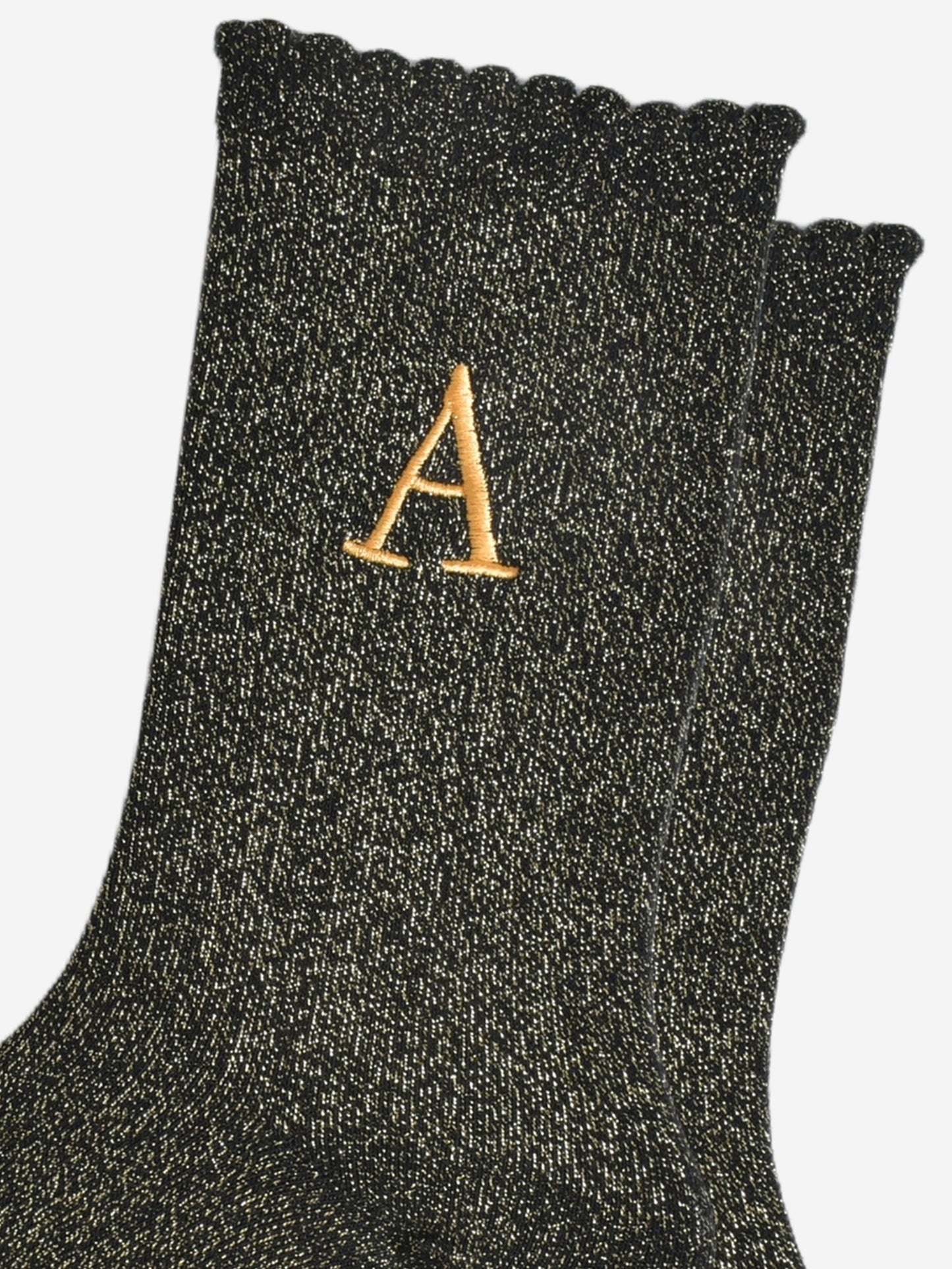 close up of the gold embroidered capital letter a on the ankle of the socks