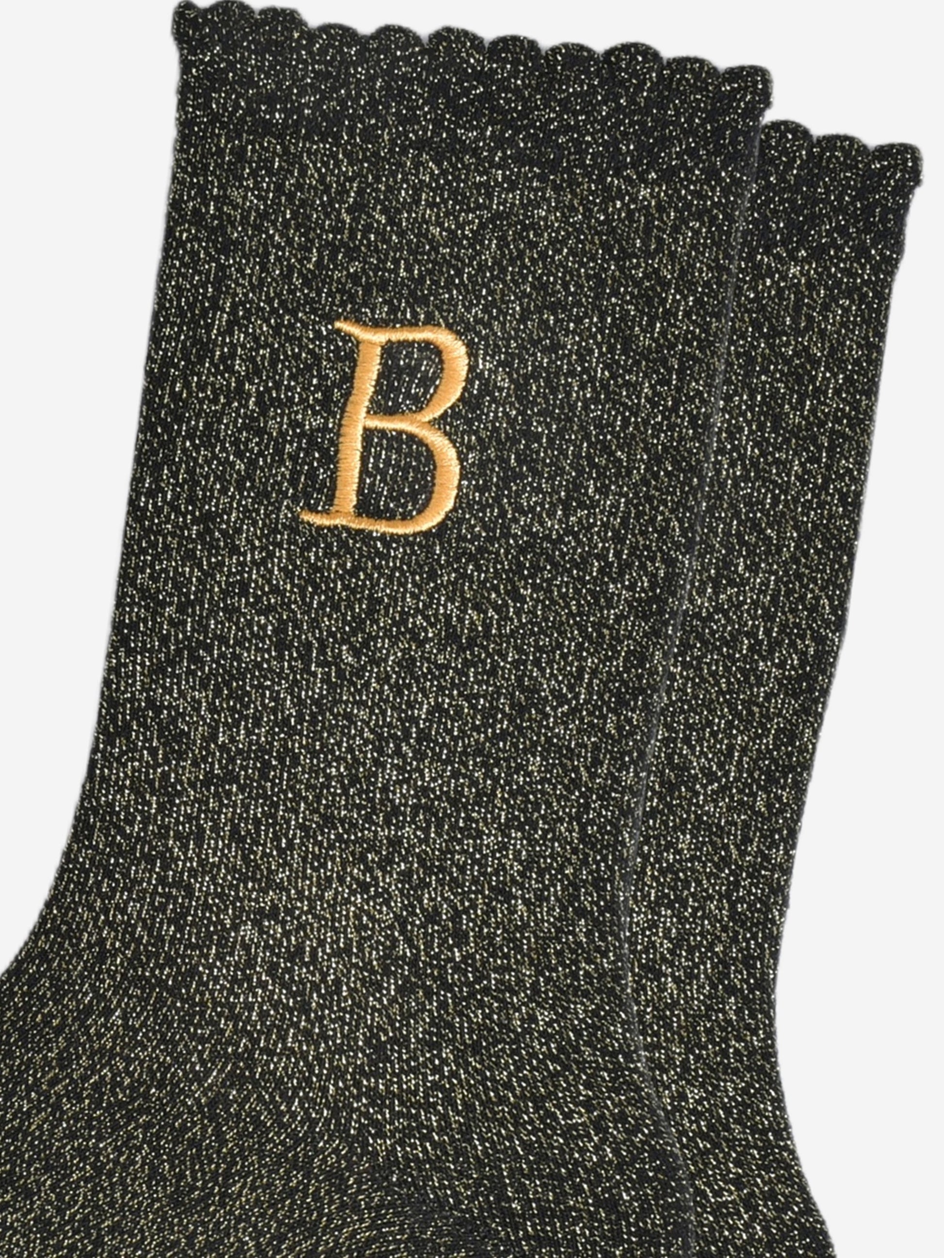 close up of the gold embroidered capital letter b on the ankle of the socks