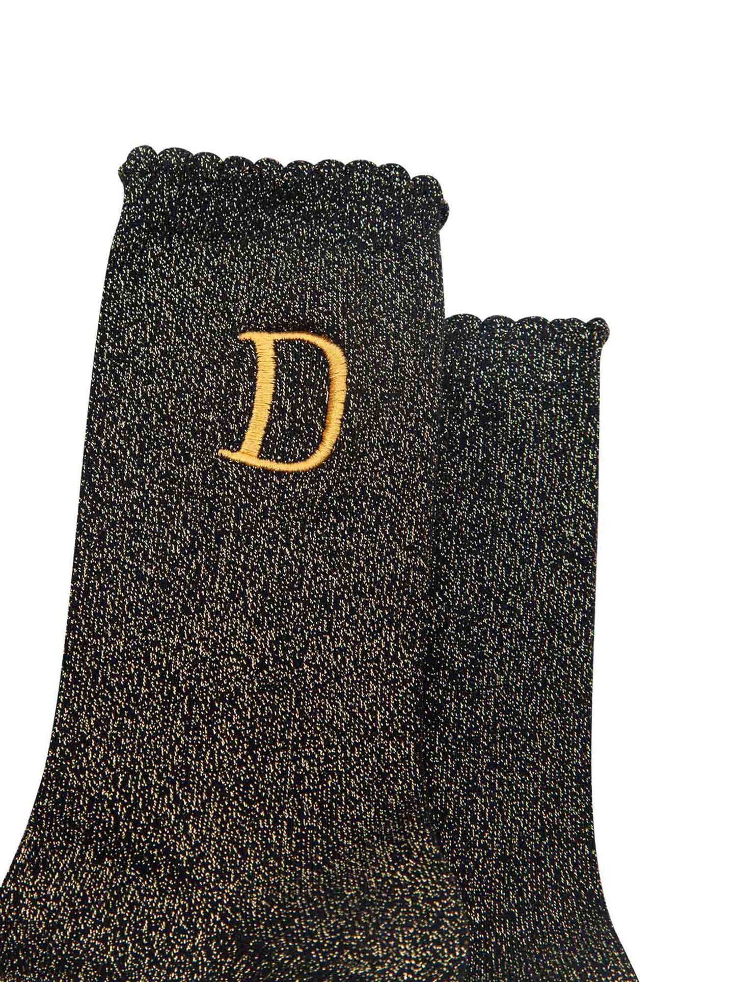 close up of the gold embroidered capital letter d on the ankle of the socks