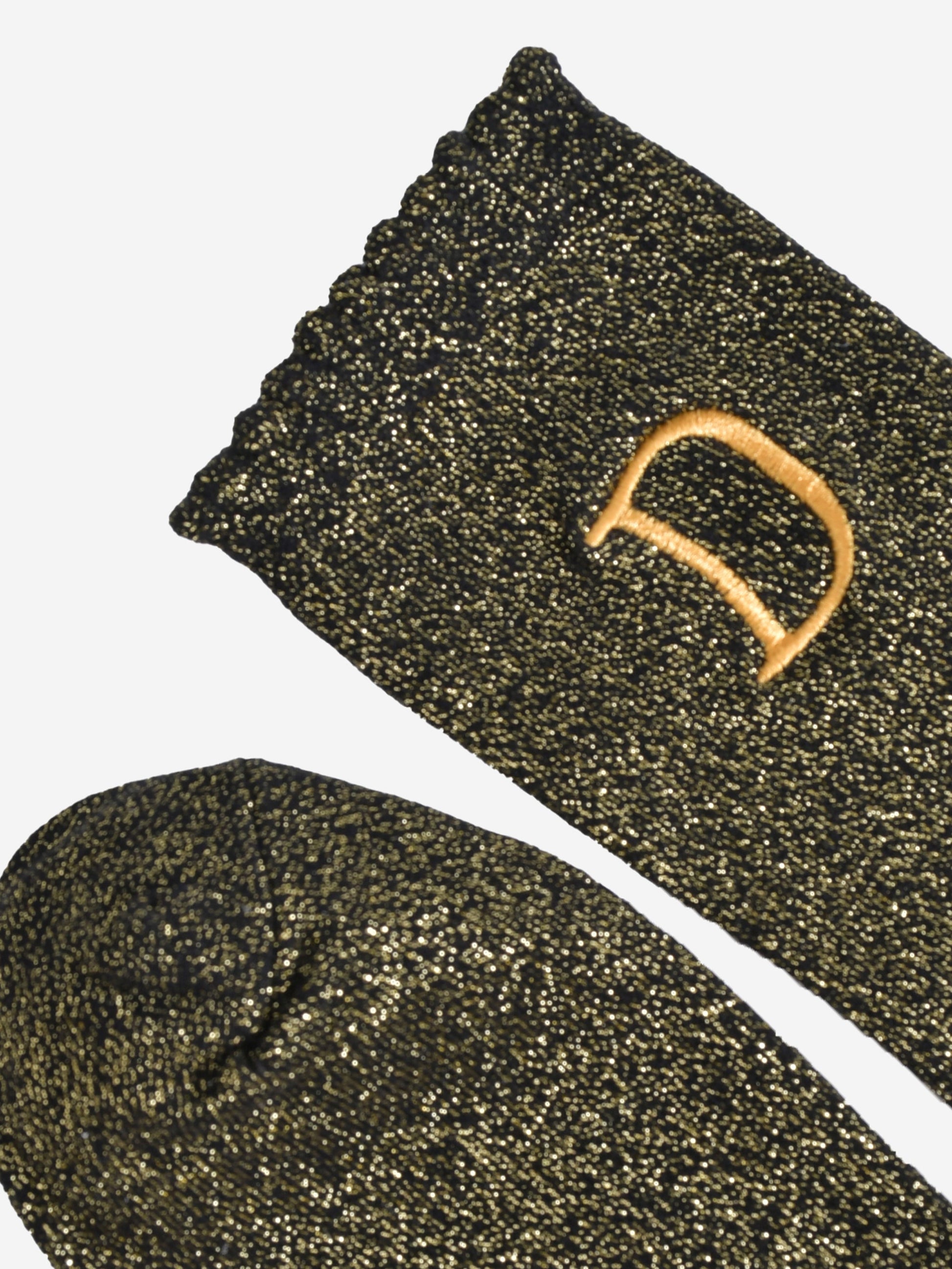 close up of the scalloped cuff on the socks, the toe is the same black and gold as the rest of the socks