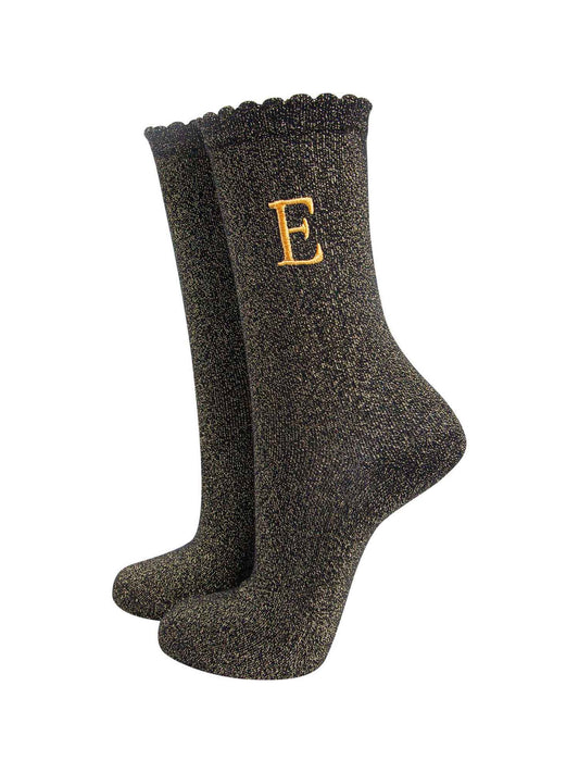 black ankle socks with a scalloped cuff, with an all over gold glitter sparkle and an embroidered gold letter e on the ankle