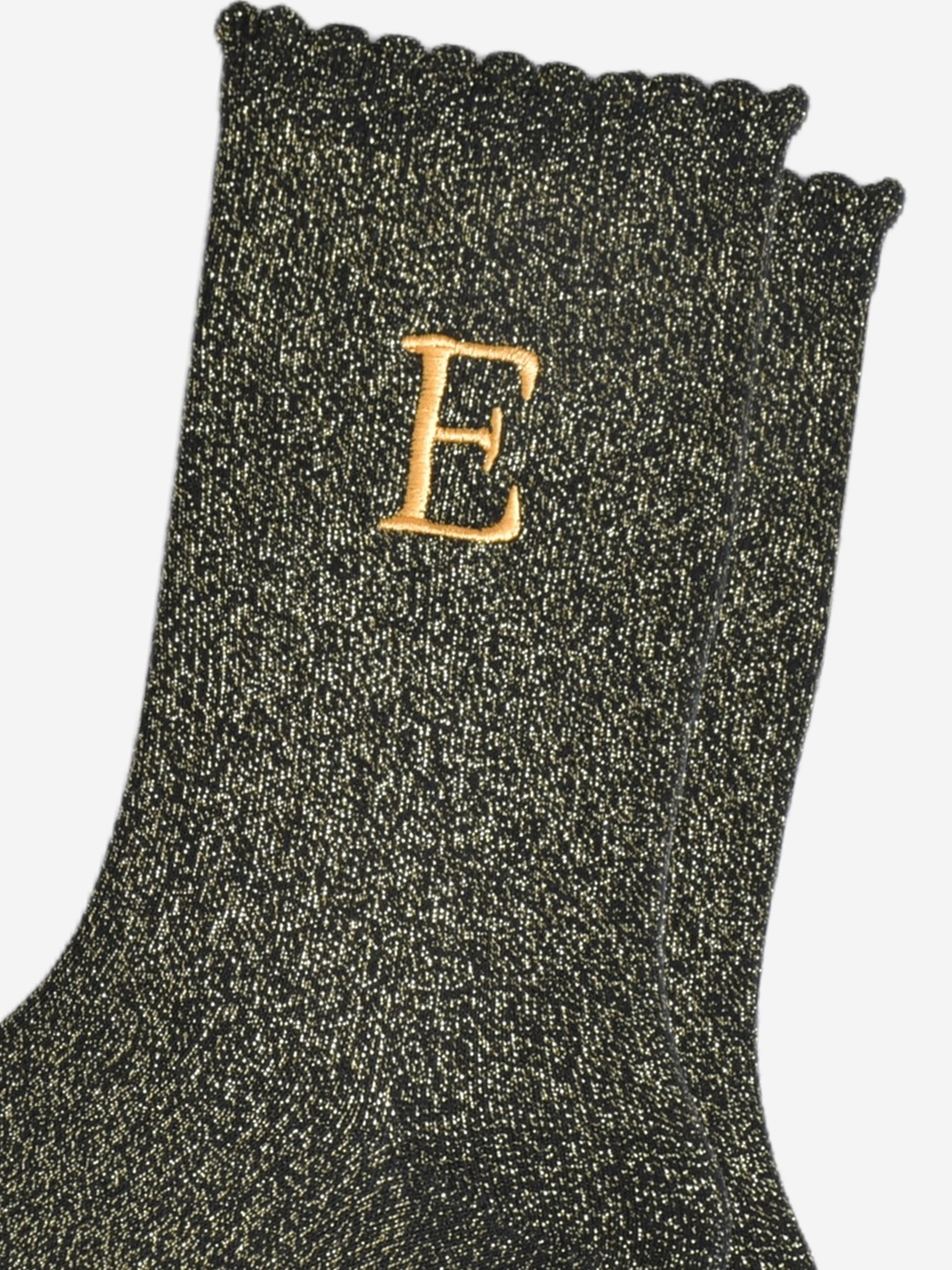 close up of the gold embroidered capital letter e on the ankle of the socks