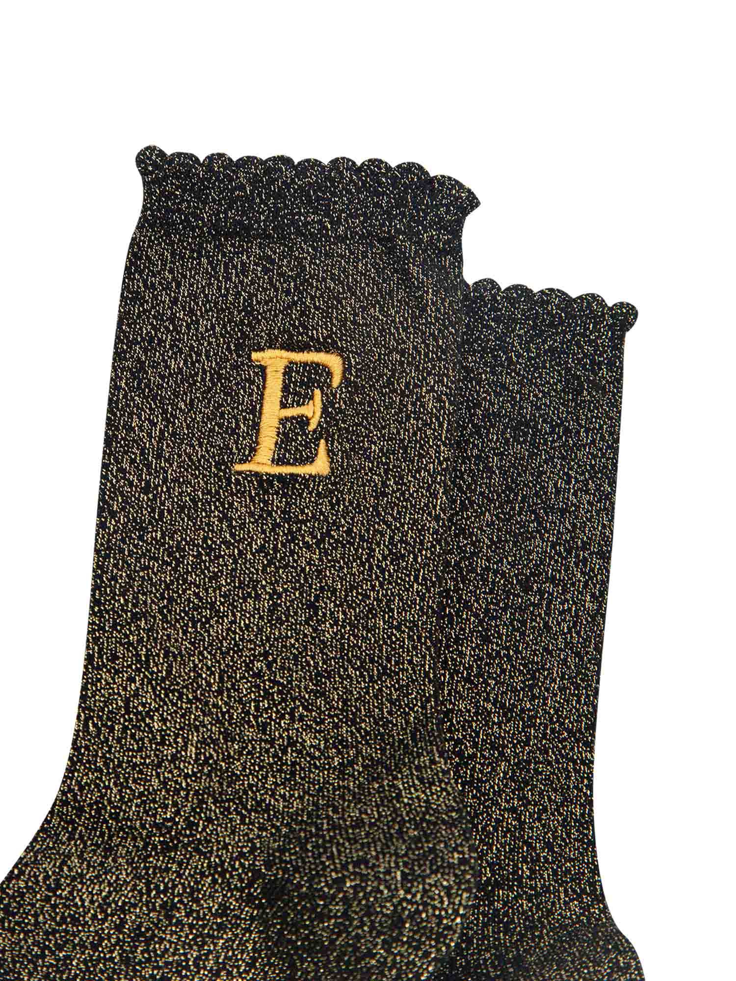 close up of the gold embroidered capital letter e on the ankle of the socks