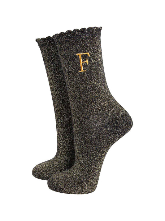black ankle socks with a scalloped cuff, with an all over gold glitter sparkle and an embroidered gold letter f on the ankle