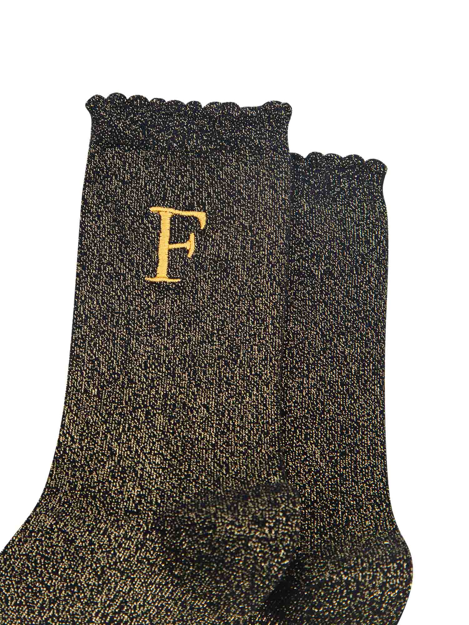close up of the gold embroidered capital letter f on the ankle of the socks