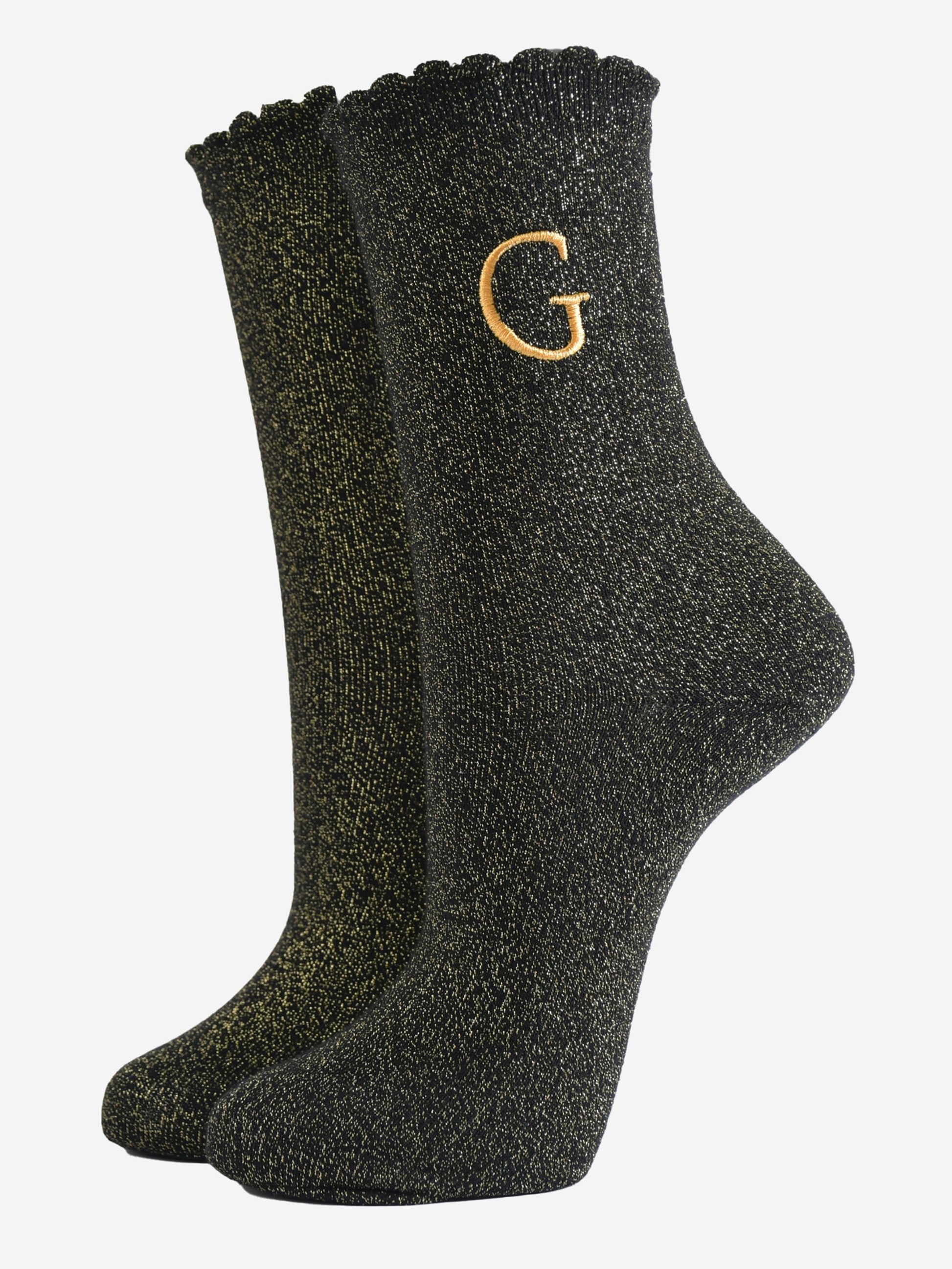 black ankle socks with a scalloped cuff, with an all over gold glitter sparkle and an embroidered gold letter g on the ankle