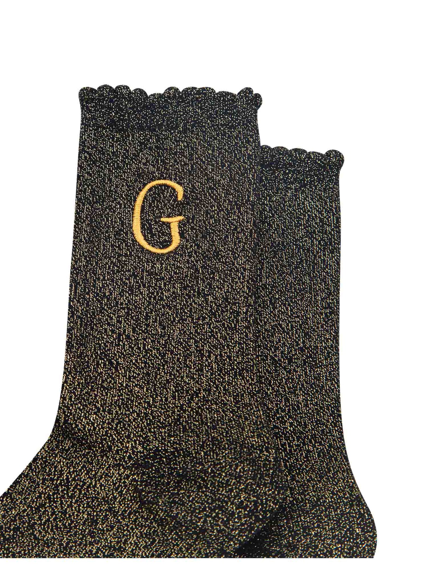 close up of the gold embroidered capital letter g on the ankle of the socks
