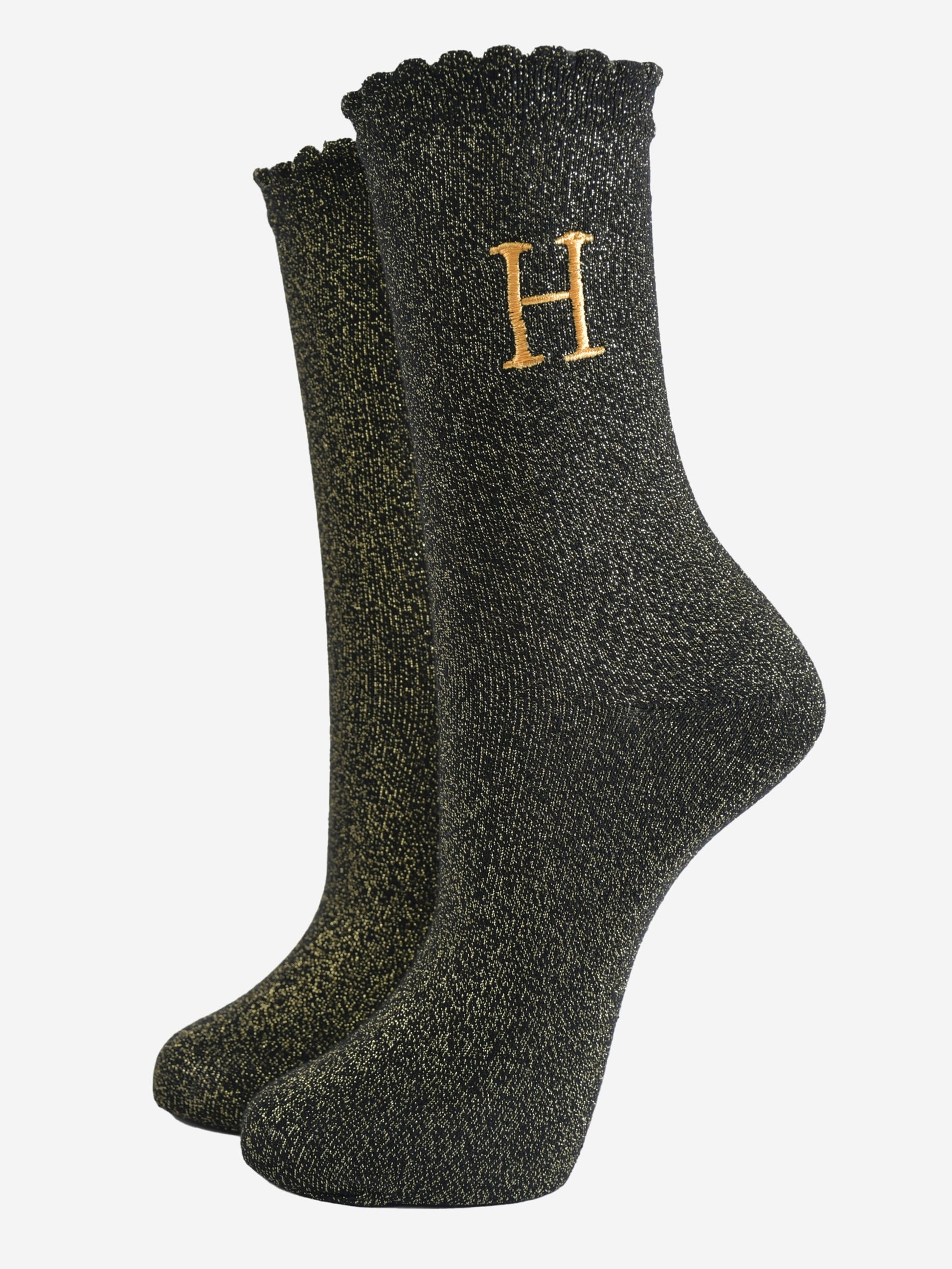 black ankle socks with a scalloped cuff, with an all over gold glitter sparkle and an embroidered gold letter h on the ankle