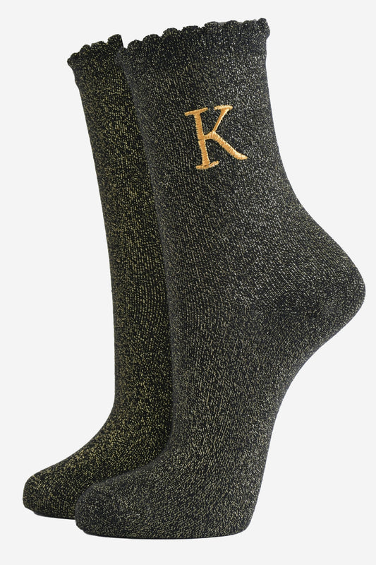 black ankle socks with a scalloped cuff, with an all over gold glitter sparkle and an embroidered gold letter k on the ankle