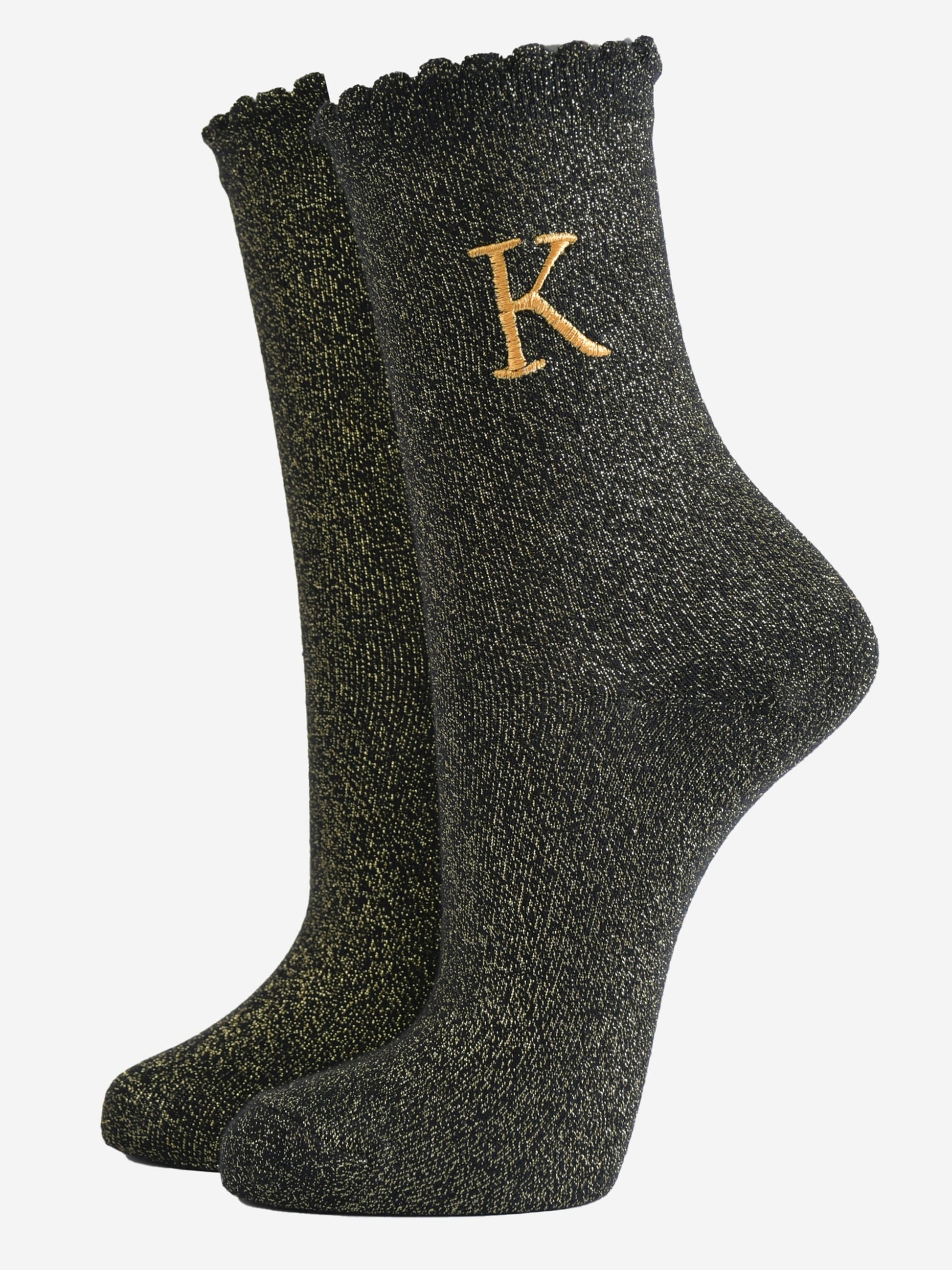 black ankle socks with a scalloped cuff, with an all over gold glitter sparkle and an embroidered gold letter k on the ankle