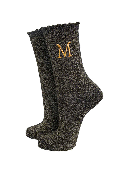 black ankle socks with a scalloped cuff, with an all over gold glitter sparkle and an embroidered gold letter m on the ankle