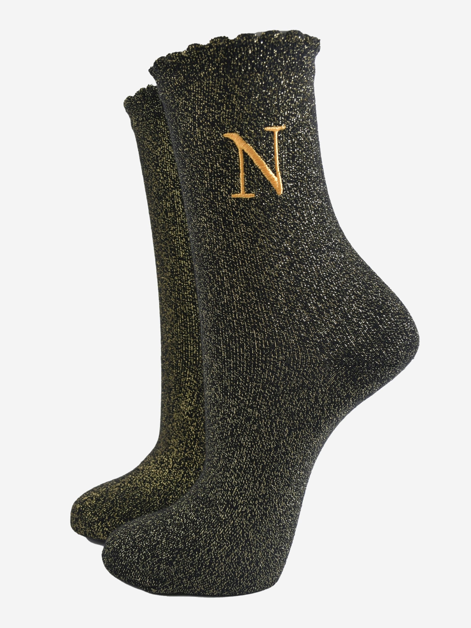 black ankle socks with a scalloped cuff, with an all over gold glitter sparkle and an embroidered gold letter n on the ankle